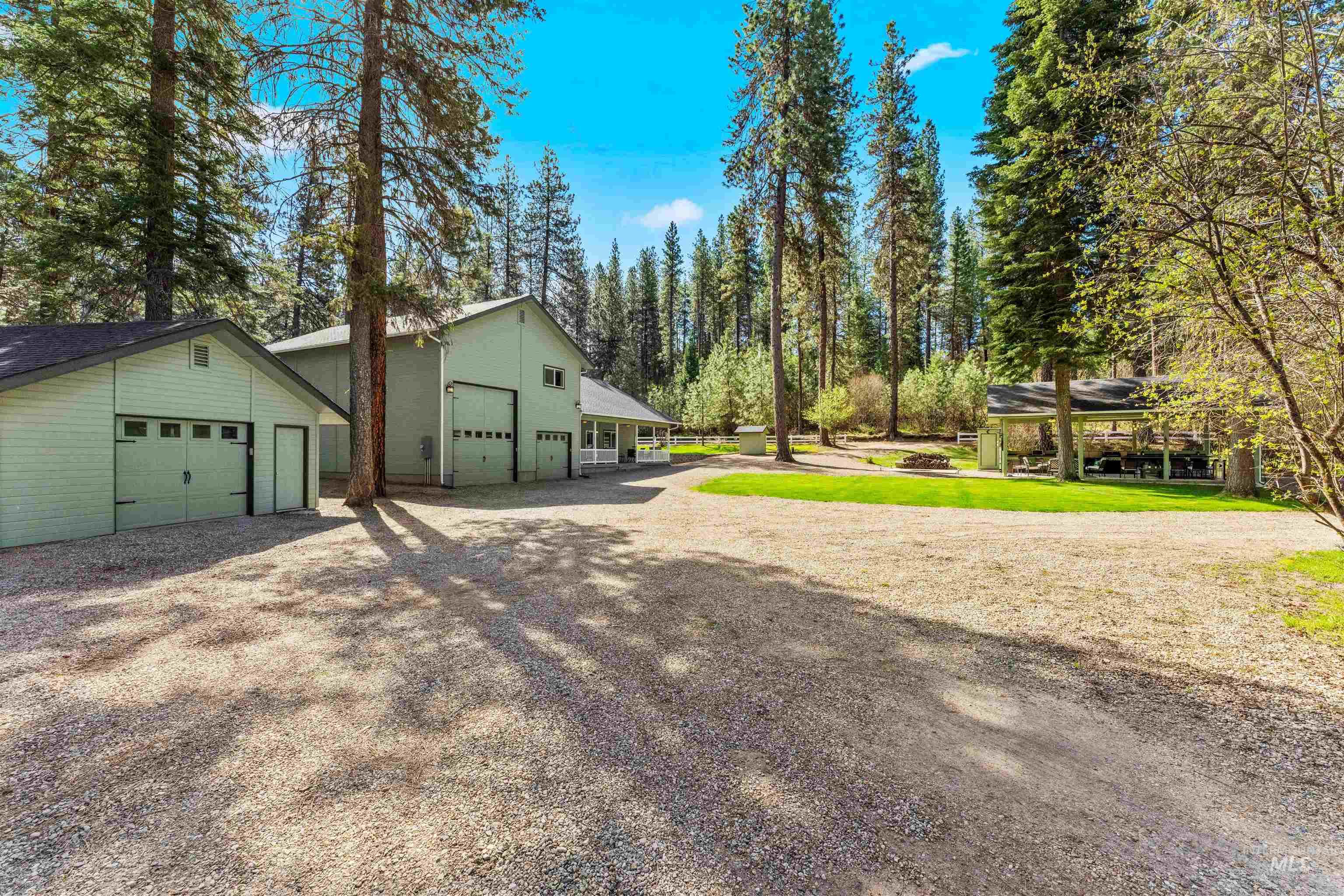 View of green lawn with a garage, driveway, and an outdoor structure