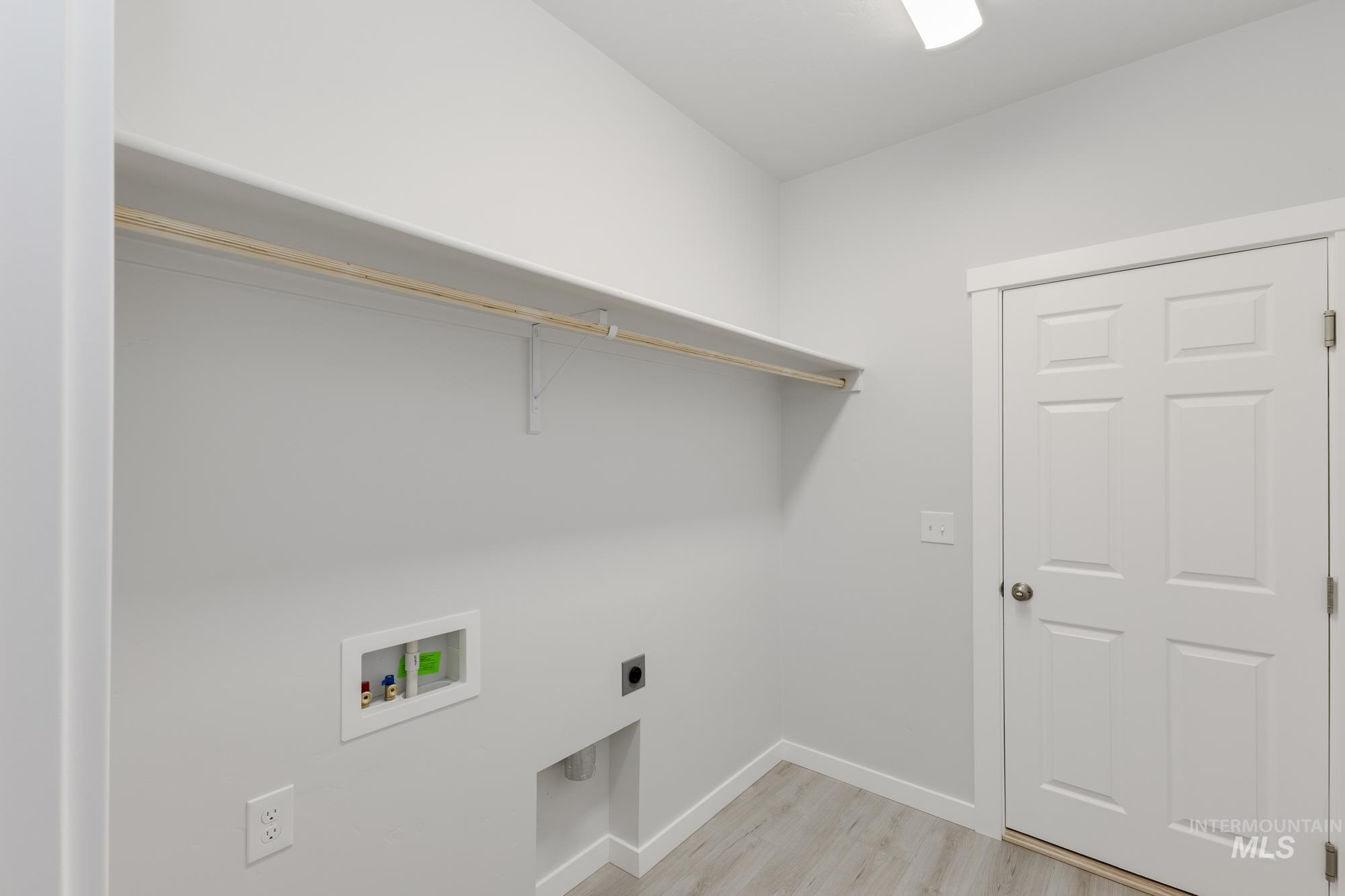 Laundry area featuring light wood-style flooring, hookup for an electric dryer, and hookup for a washing machine