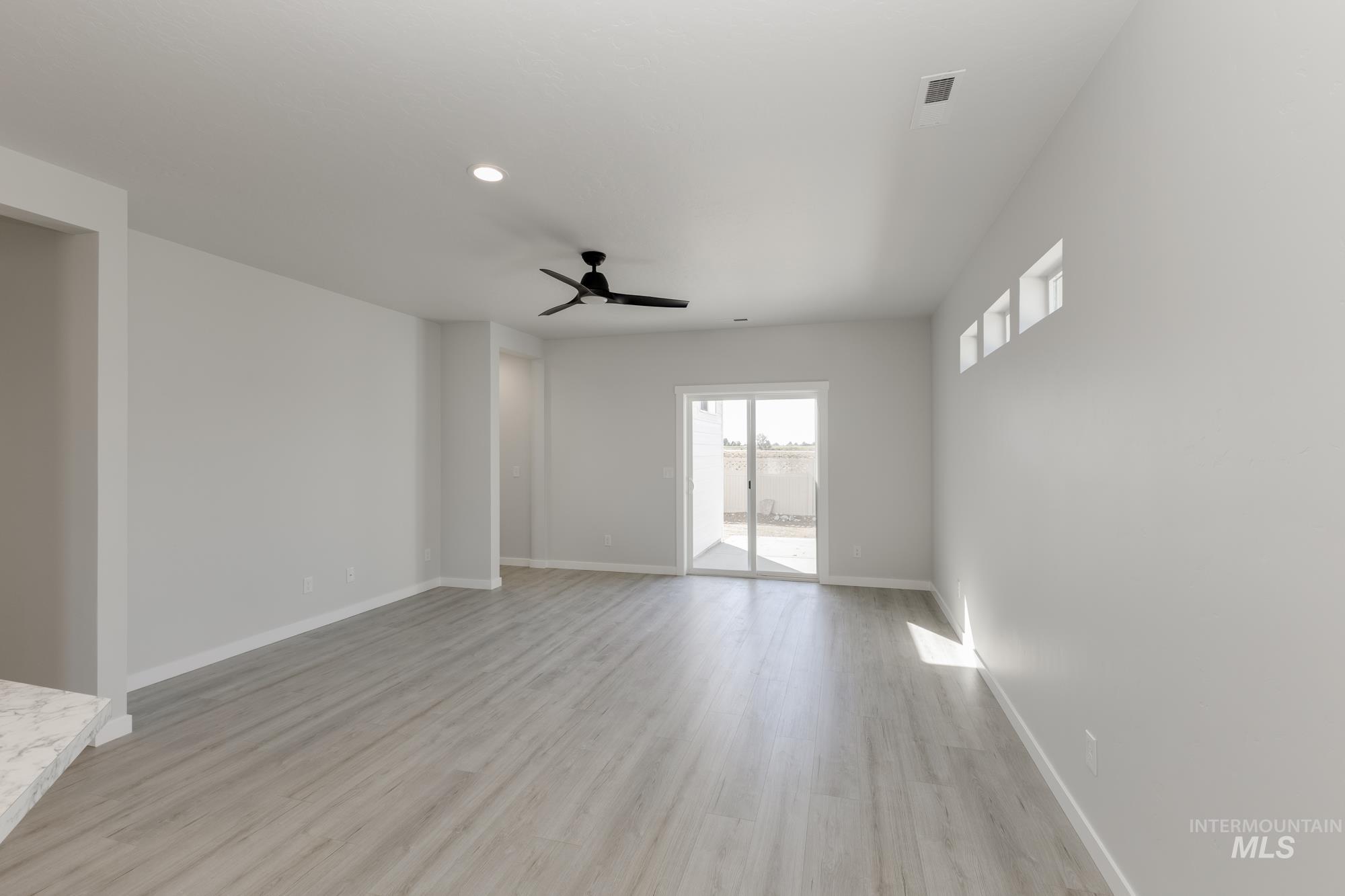 Spare room with light wood finished floors, ceiling fan, and recessed lighting