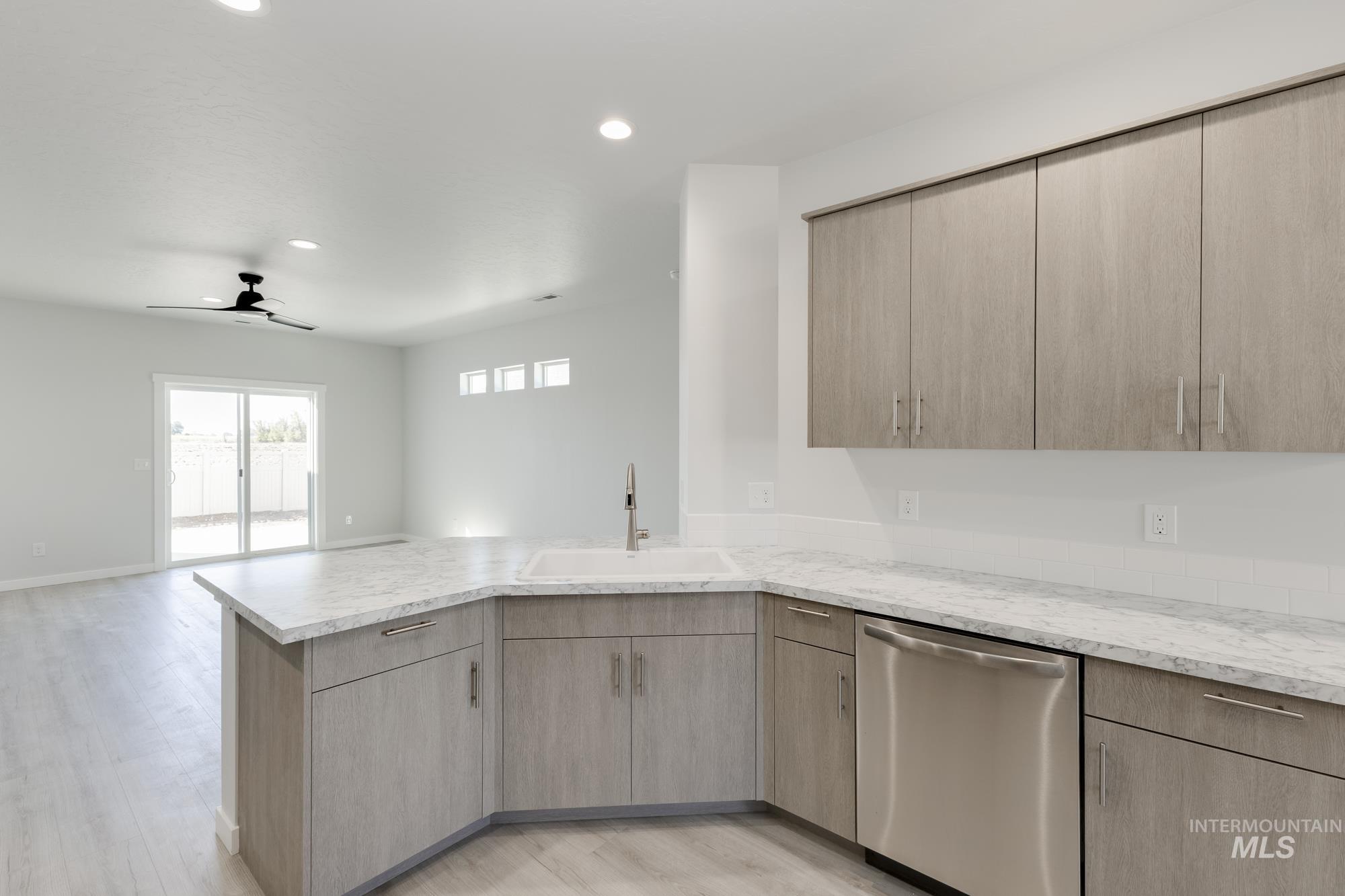 Kitchen featuring light brown cabinets, dishwasher, open floor plan, a ceiling fan, and recessed lighting