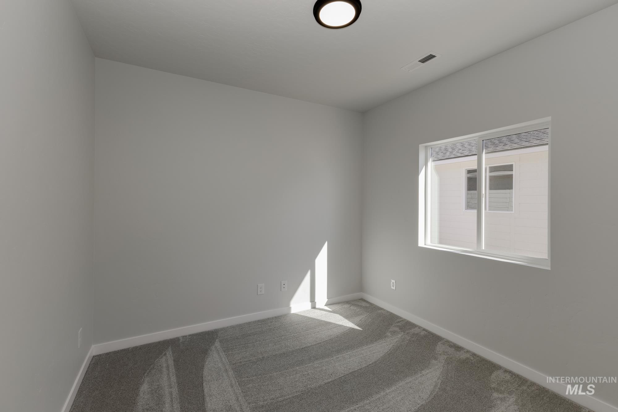 Carpeted empty room featuring baseboards