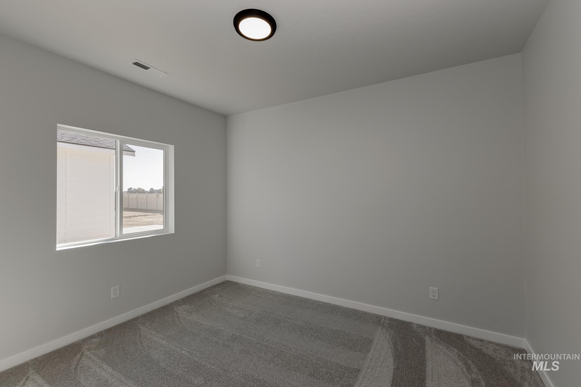 Carpeted empty room with baseboards