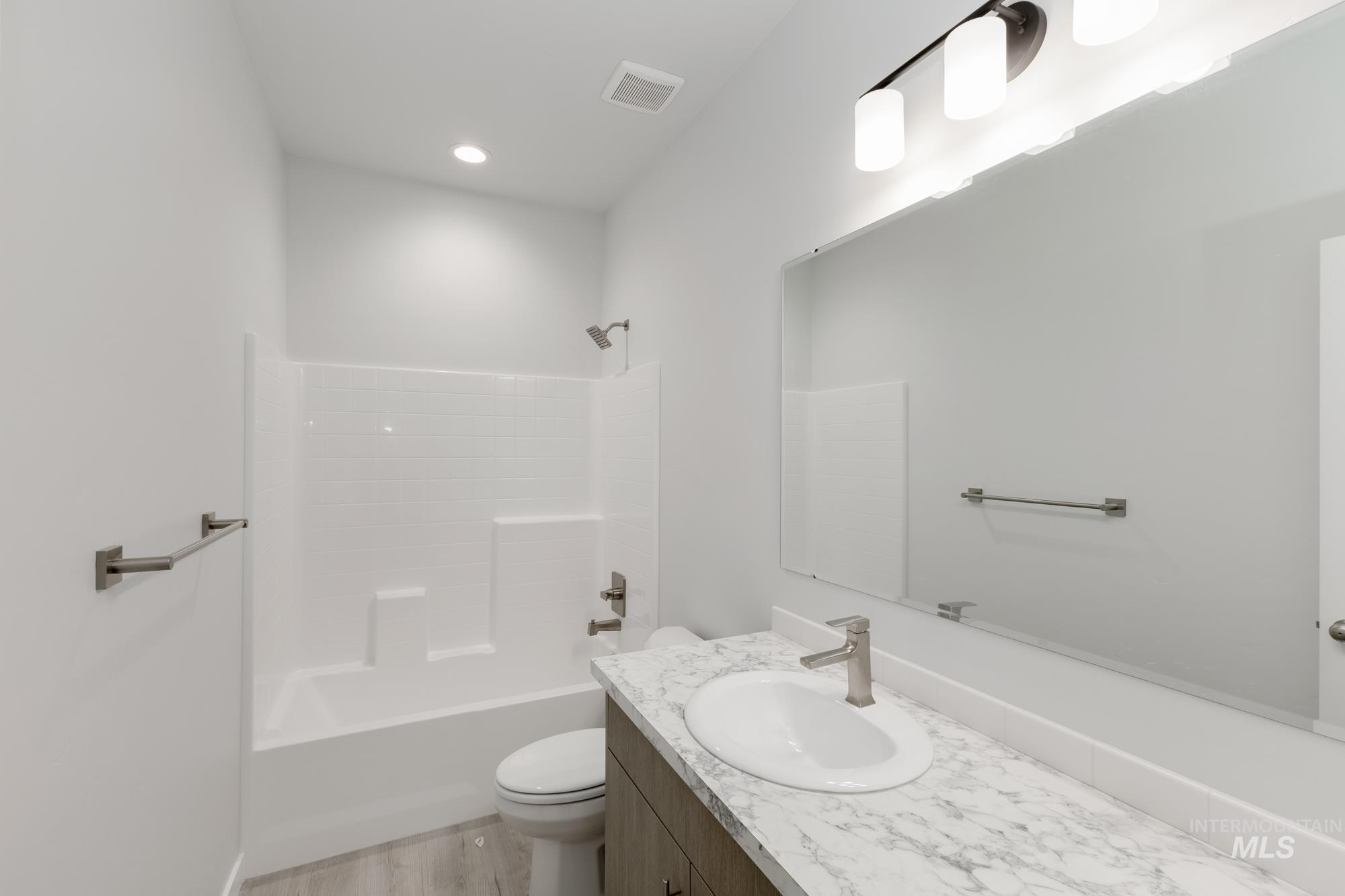 Full bath with vanity, shower / bathtub combination, light wood-style flooring, and recessed lighting