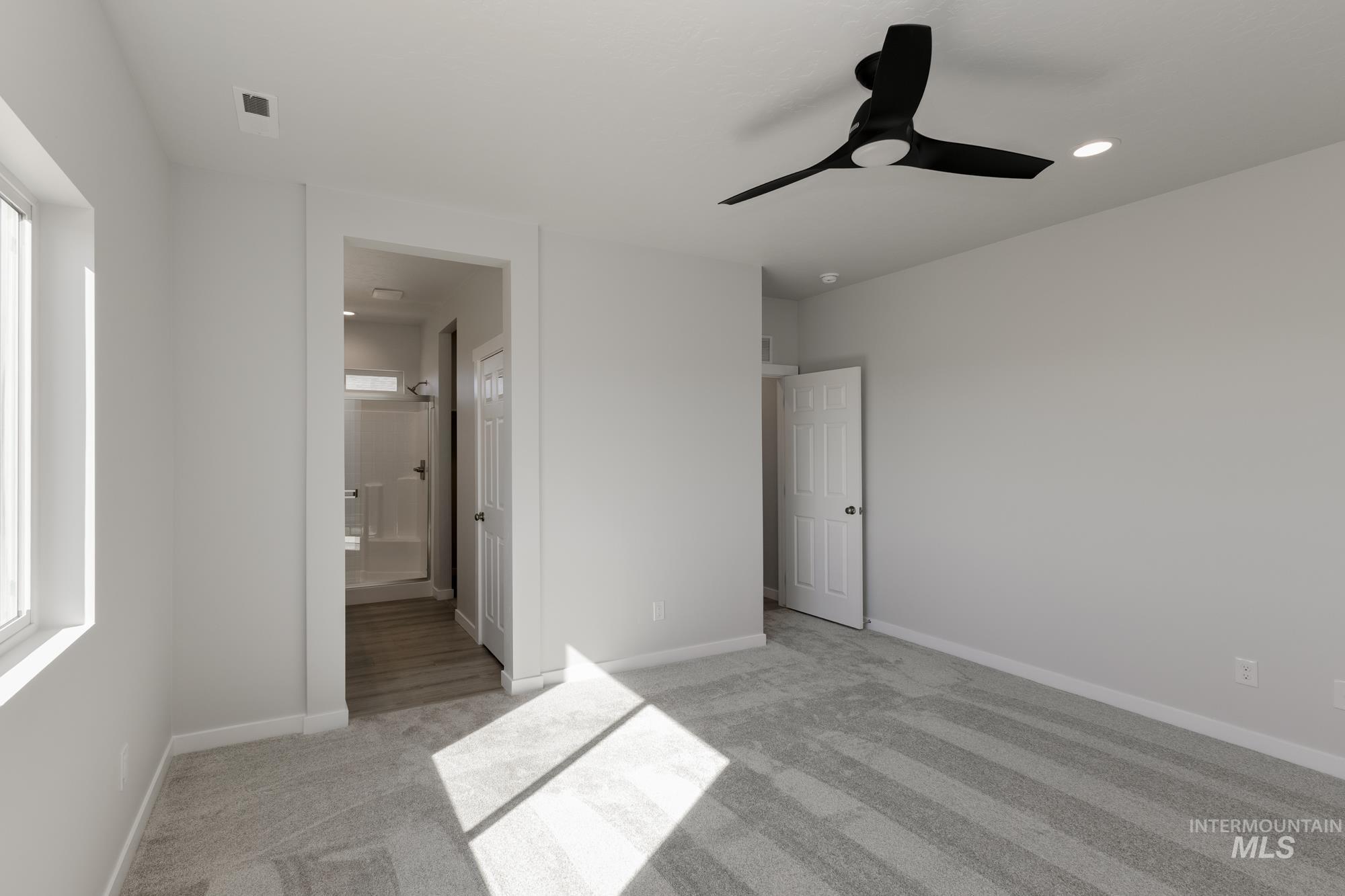 Unfurnished bedroom with light carpet, a ceiling fan, ensuite bathroom, and recessed lighting