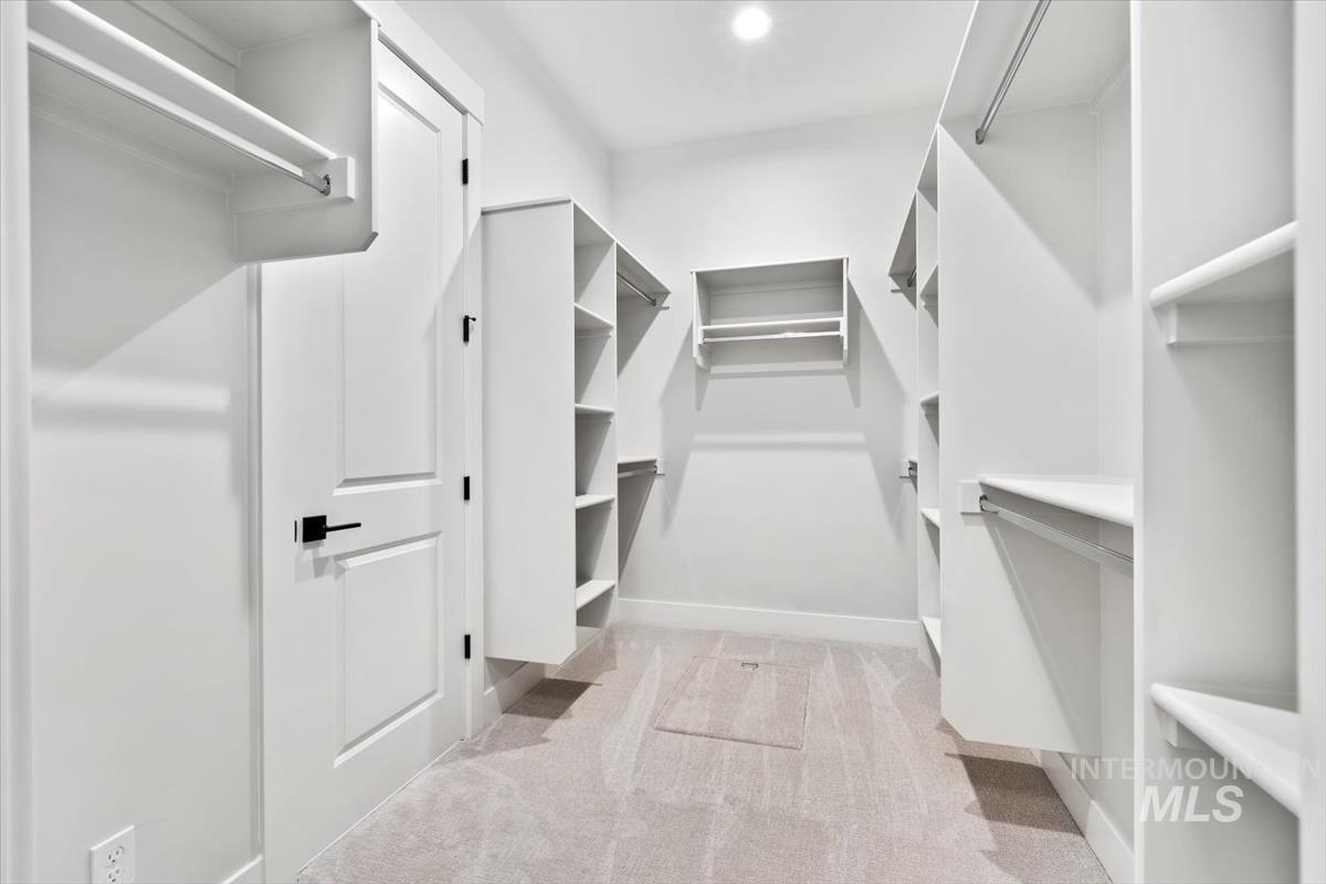 Walk in closet with light colored carpet