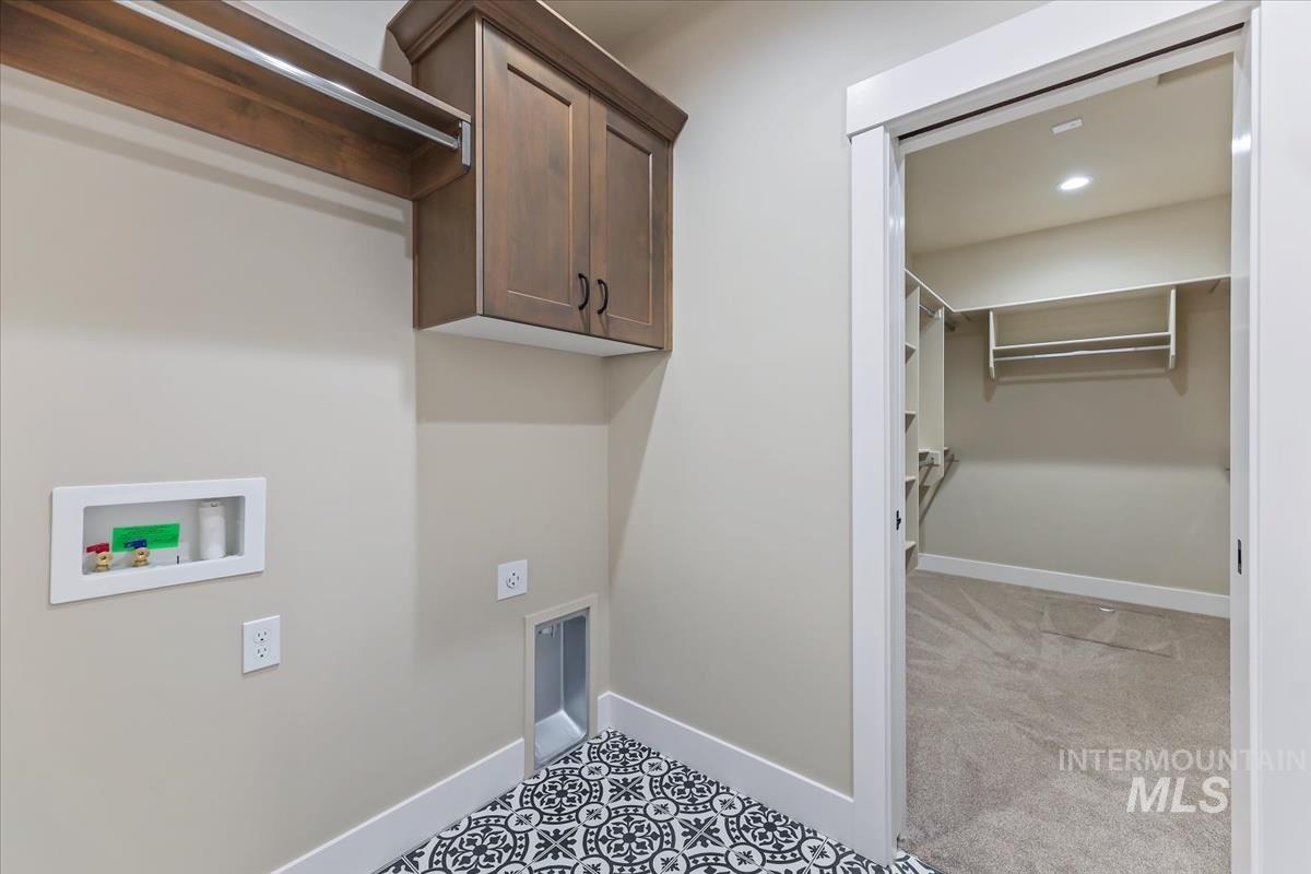 Laundry area with cabinet space, washer hookup, light tile patterned floors, and recessed lighting