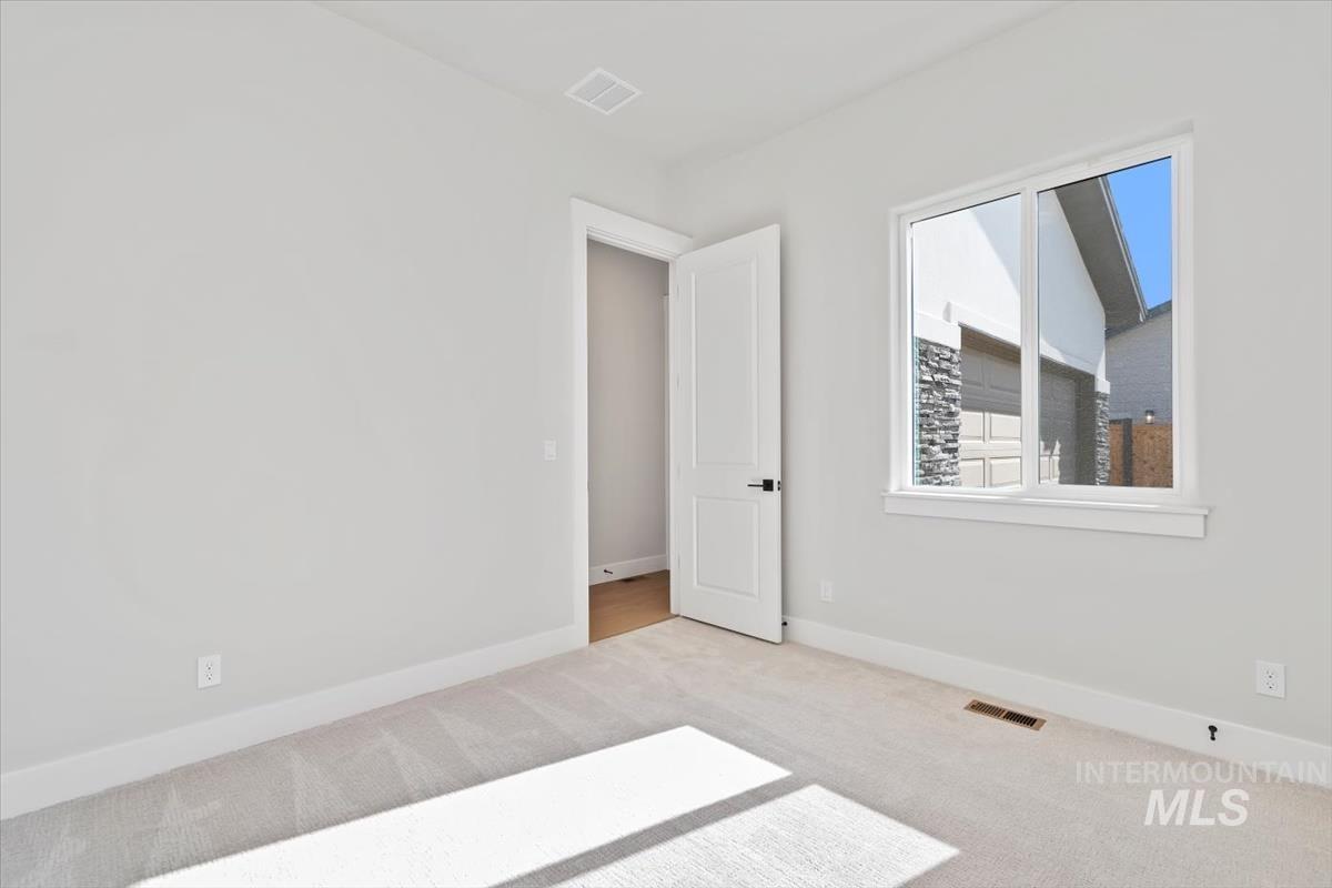 Spare room with light colored carpet and baseboards