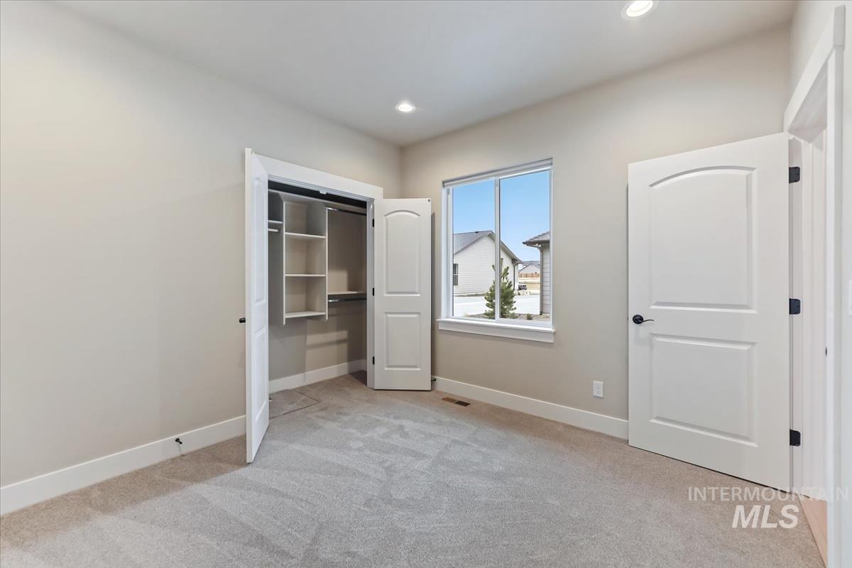 Unfurnished bedroom with light carpet, a closet, and recessed lighting