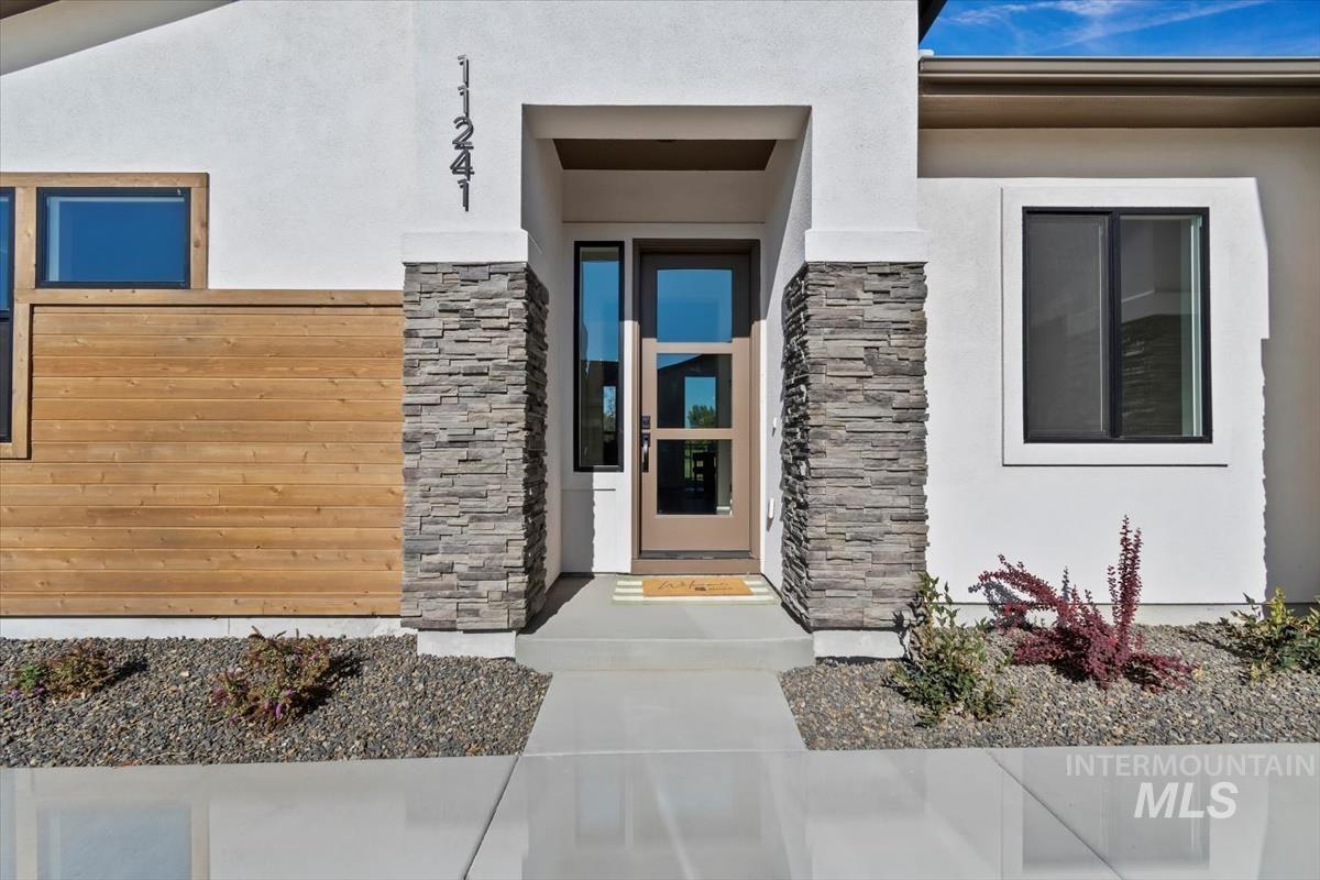 Property entrance featuring stone siding and stucco siding