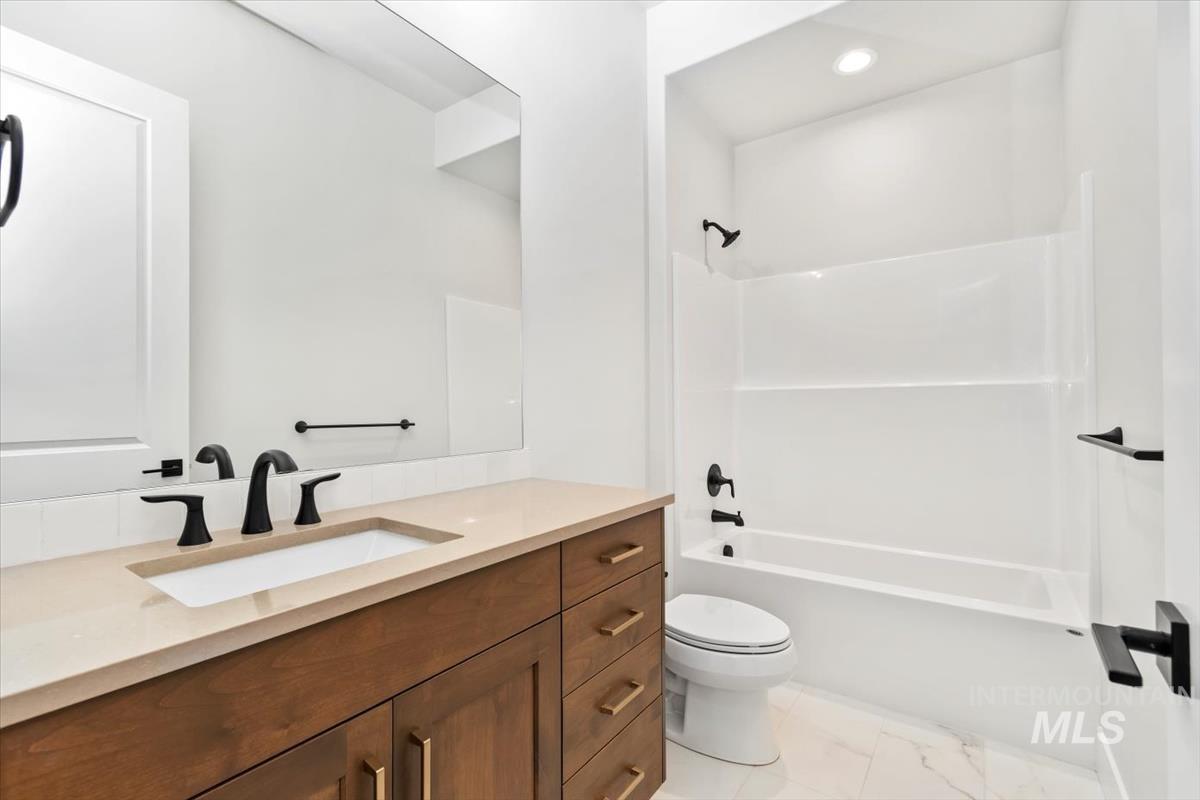 Full bathroom featuring  shower combination, vanity, and recessed lighting