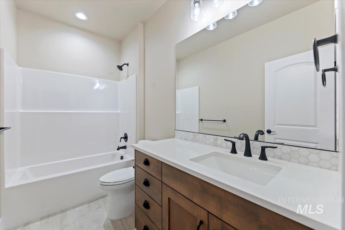 Bathroom featuring vanity,  shower combination, and recessed lighting