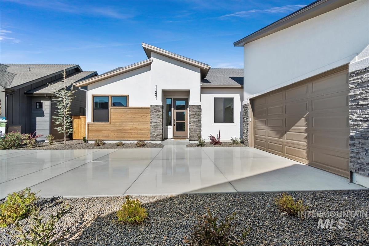 Contemporary house featuring stucco siding, stone siding, and driveway