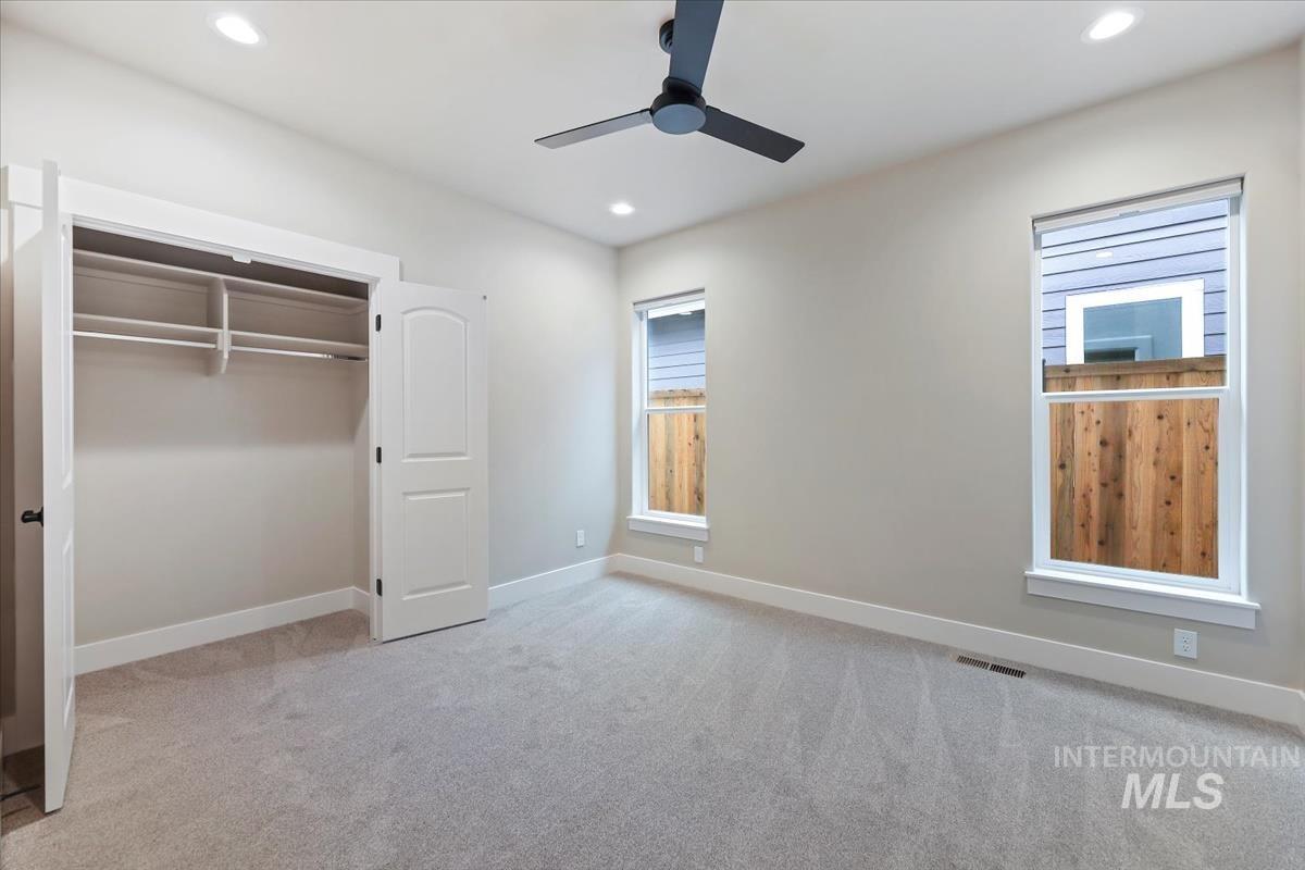 Unfurnished bedroom featuring light colored carpet, a ceiling fan, a closet, and recessed lighting