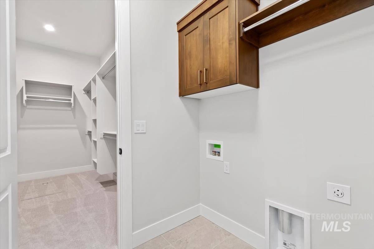 Washroom featuring cabinet space, hookup for a washing machine, light tile patterned floors, light carpet, and recessed lighting