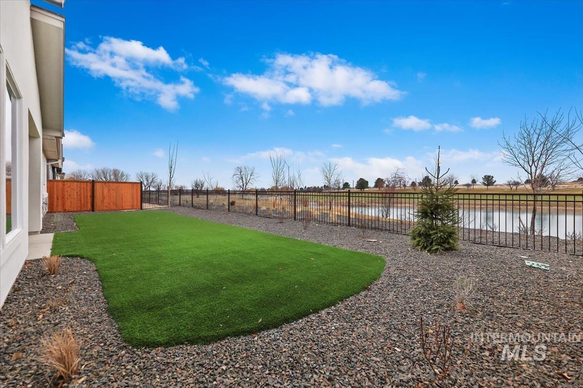 Fenced backyard with a water view