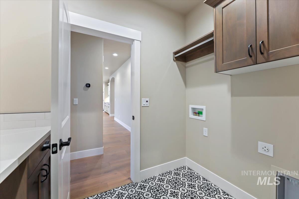 Laundry area featuring cabinet space, hookup for a washing machine, recessed lighting, and light tile patterned floors
