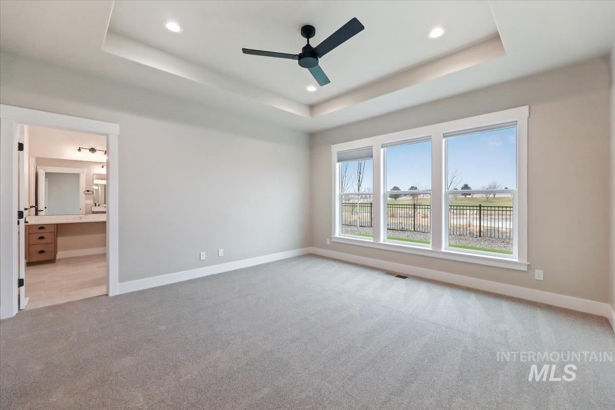 Unfurnished bedroom featuring light carpet, ceiling fan, recessed lighting, and connected bathroom