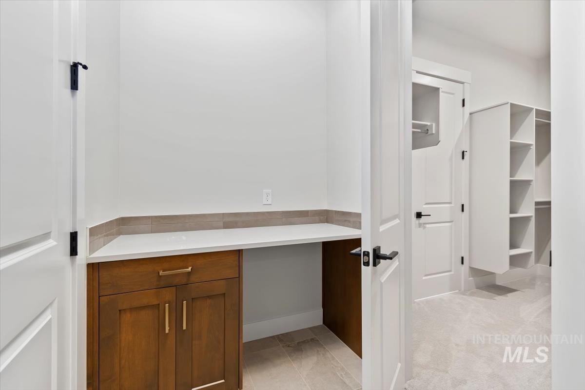 Walk in closet featuring light colored carpet