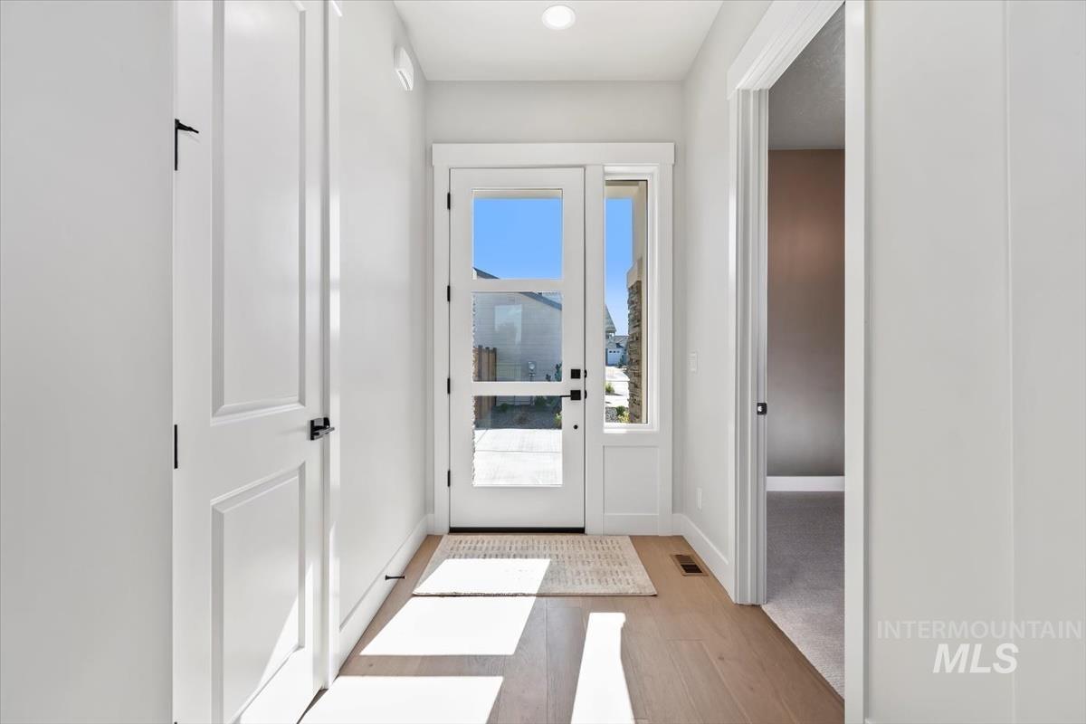 Doorway to outside featuring baseboards and wood finished floors
