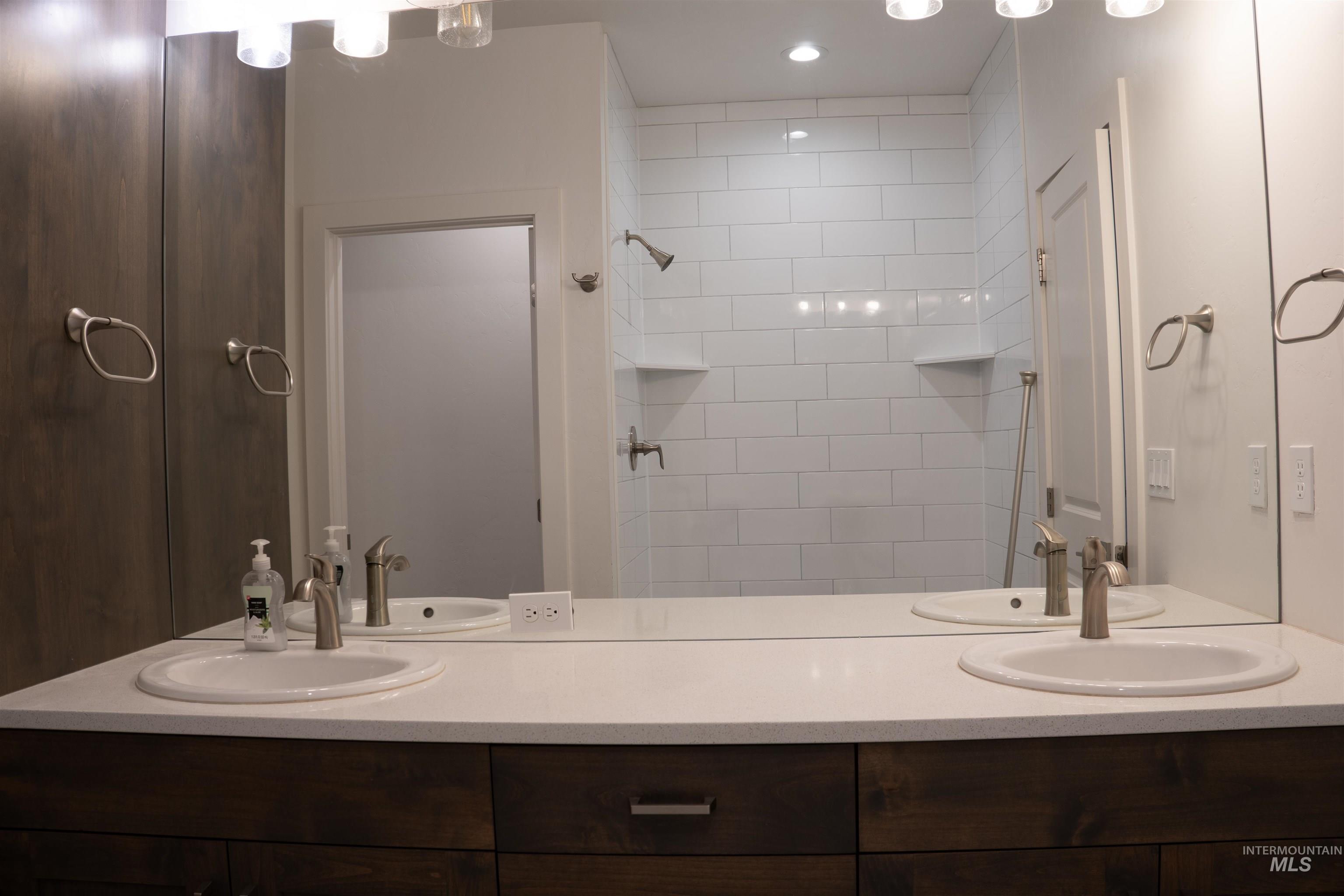 Full bathroom with double vanity and a tile shower