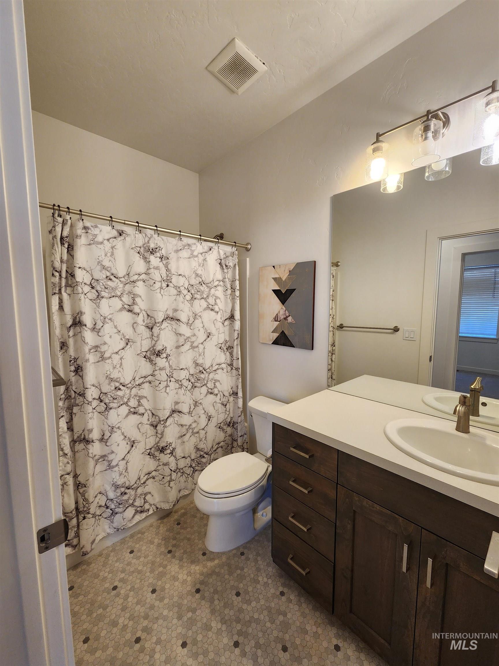 Bathroom with a shower with shower curtain and vanity