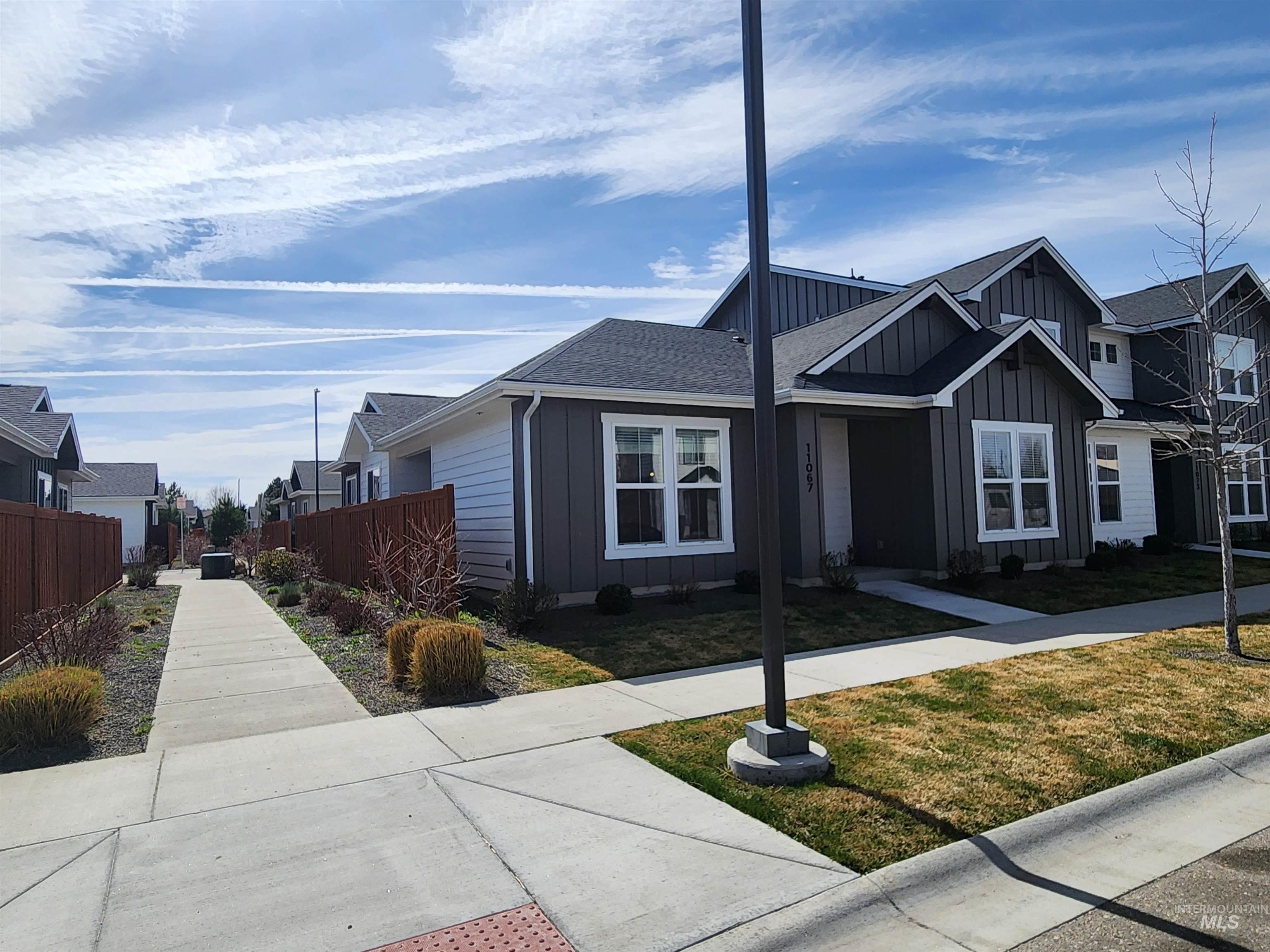 View of front of home featuring board and batten siding, a residential view, and roof with shingles