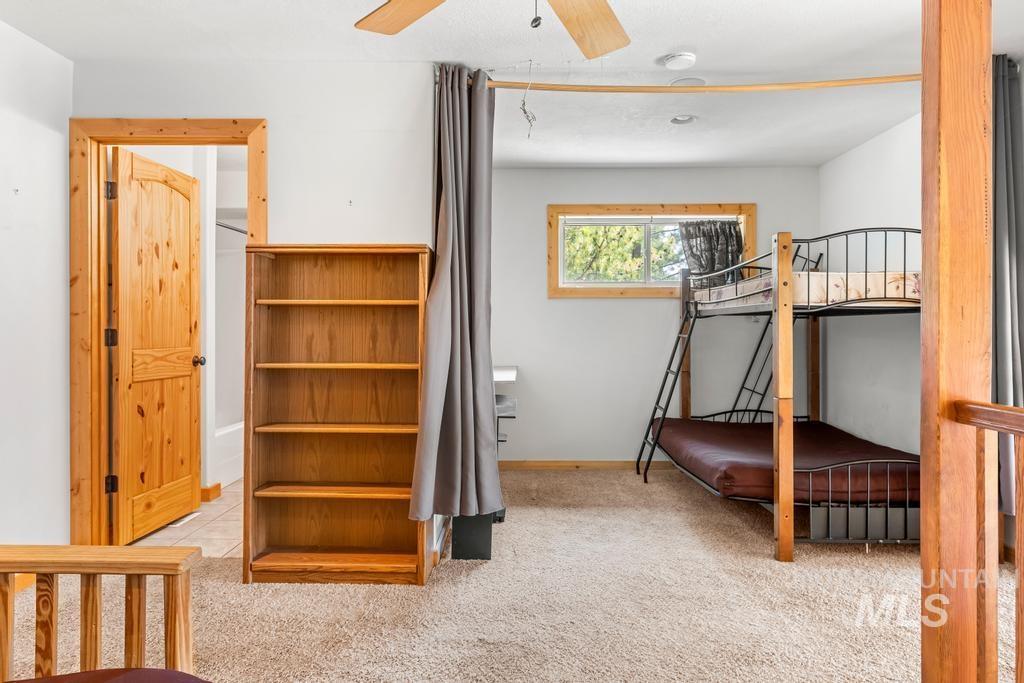 Bedroom featuring light carpet, ceiling fan, and light tile patterned floors
