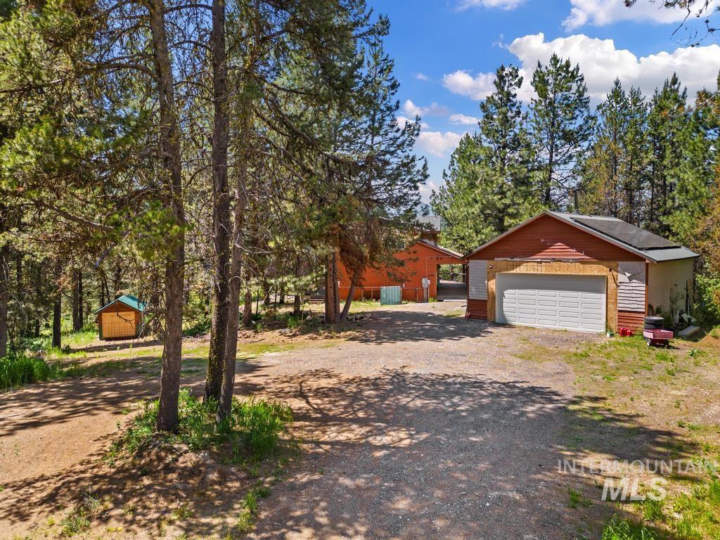 View of yard with an outbuilding, dirt driveway, and a garage