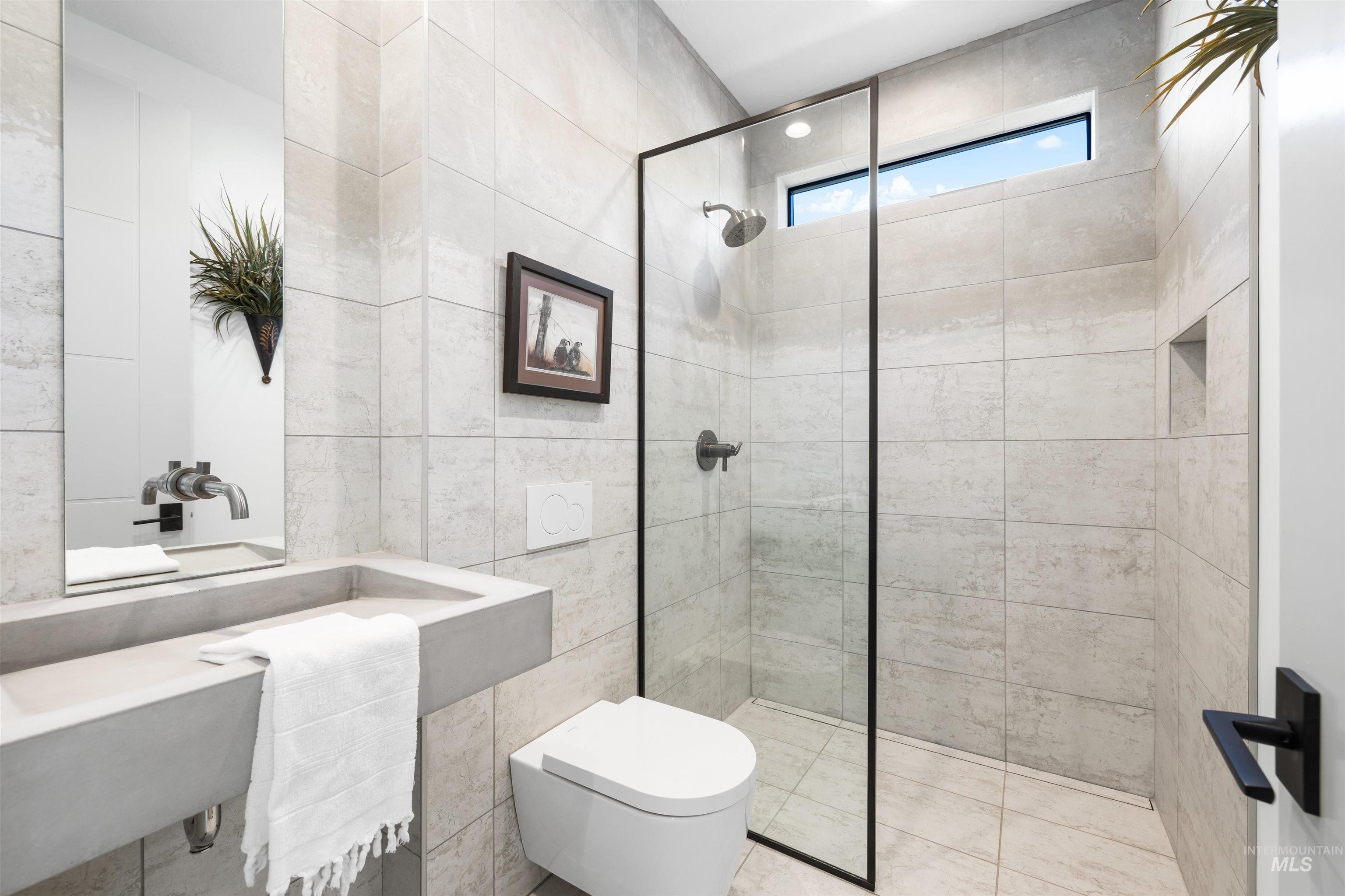 Bathroom with tile walls and walk in shower