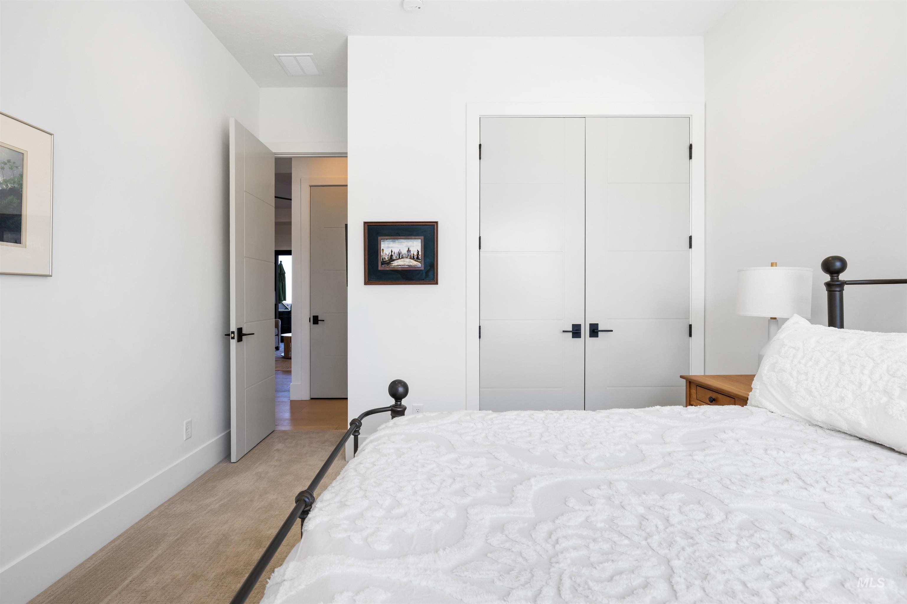 Bedroom featuring light carpet and a closet