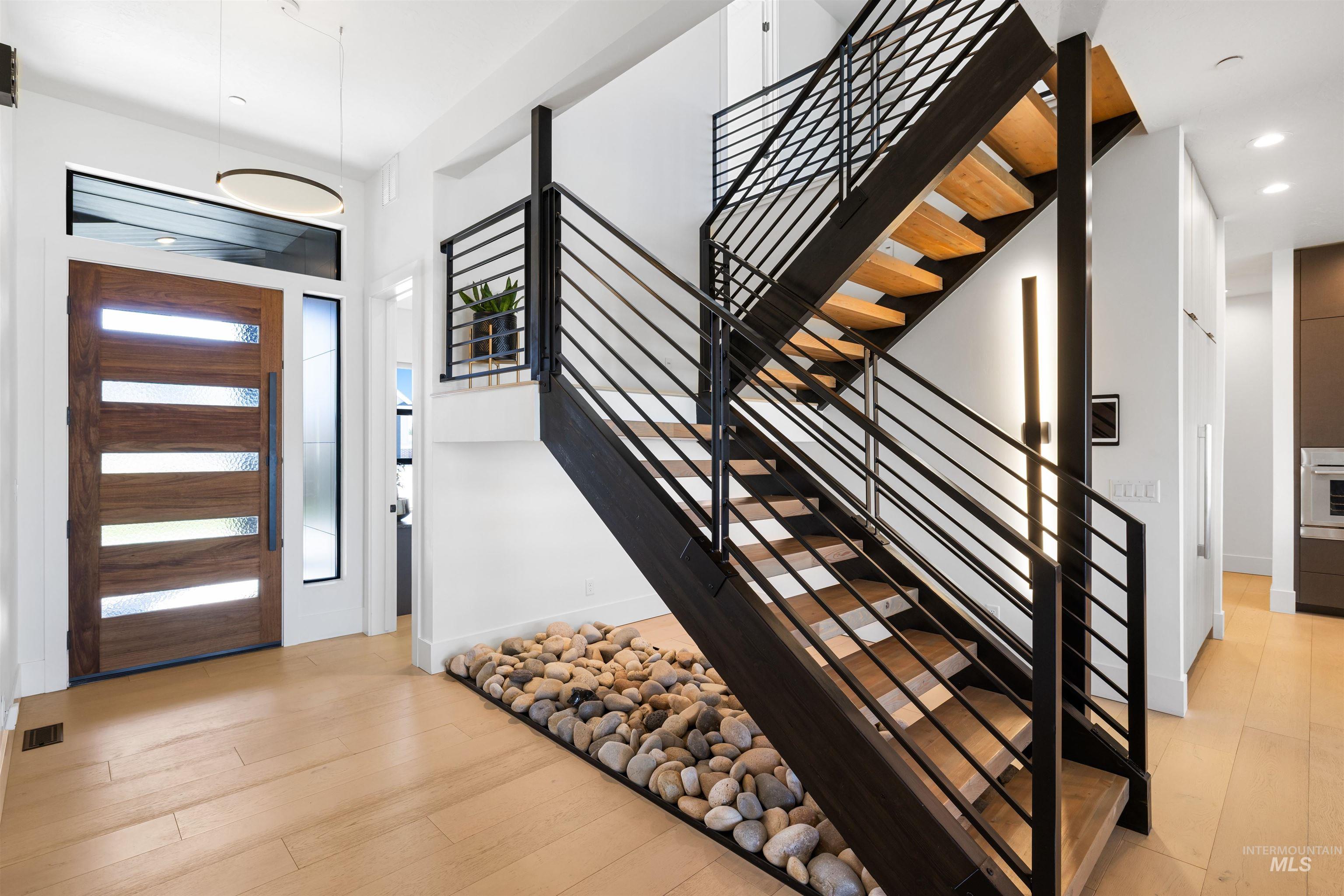 Foyer with light wood finished floors, stairway, and recessed lighting