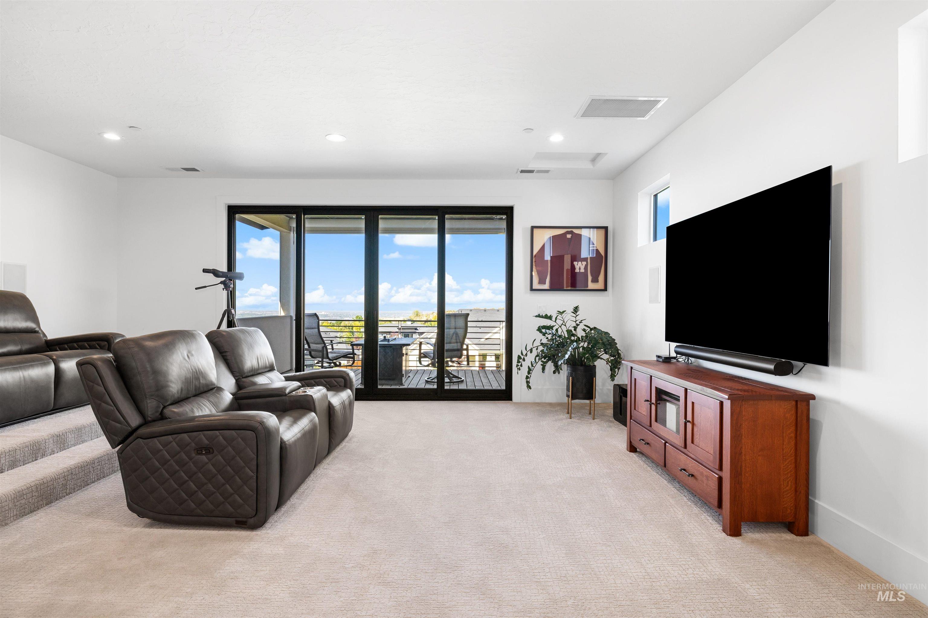 Living area with light colored carpet and recessed lighting
