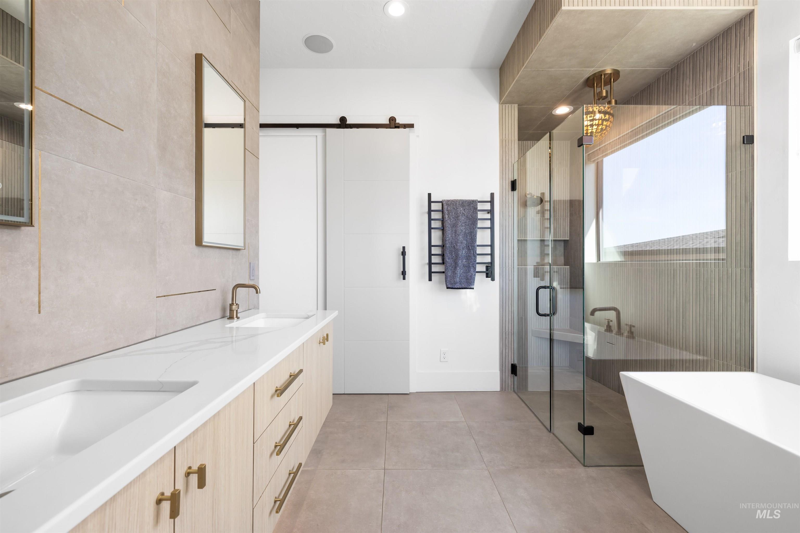 Bathroom with double vanity, a soaking tub, a shower stall, tile walls, and light tile patterned floors