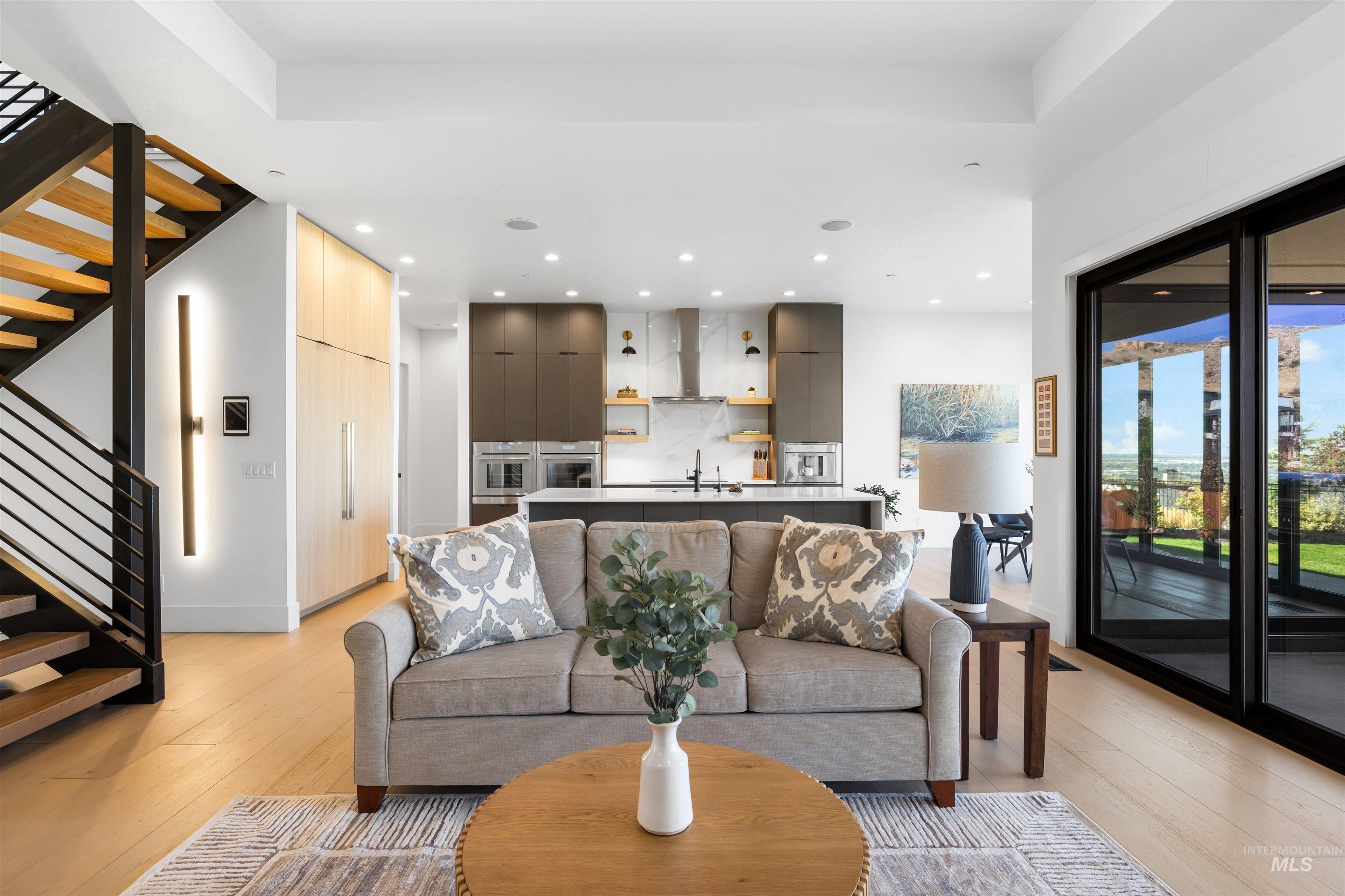 Living room with stairway, light wood-style flooring, and recessed lighting