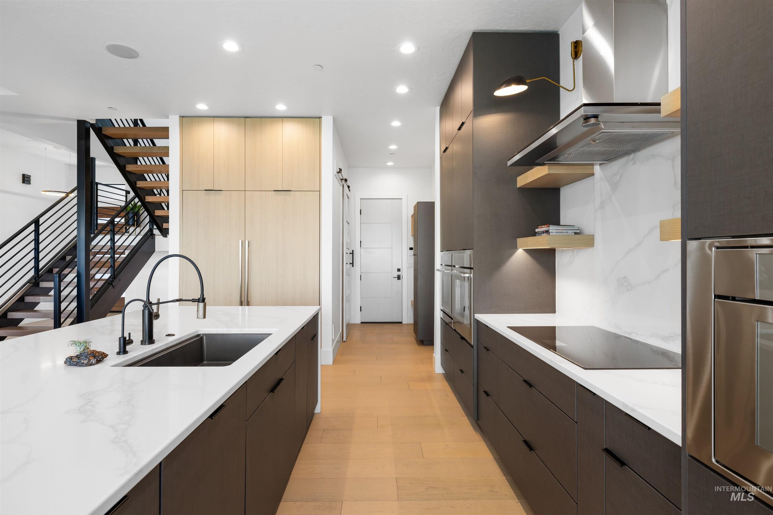 Kitchen with modern cabinets, open shelves, wall chimney exhaust hood, dark brown cabinets, and recessed lighting