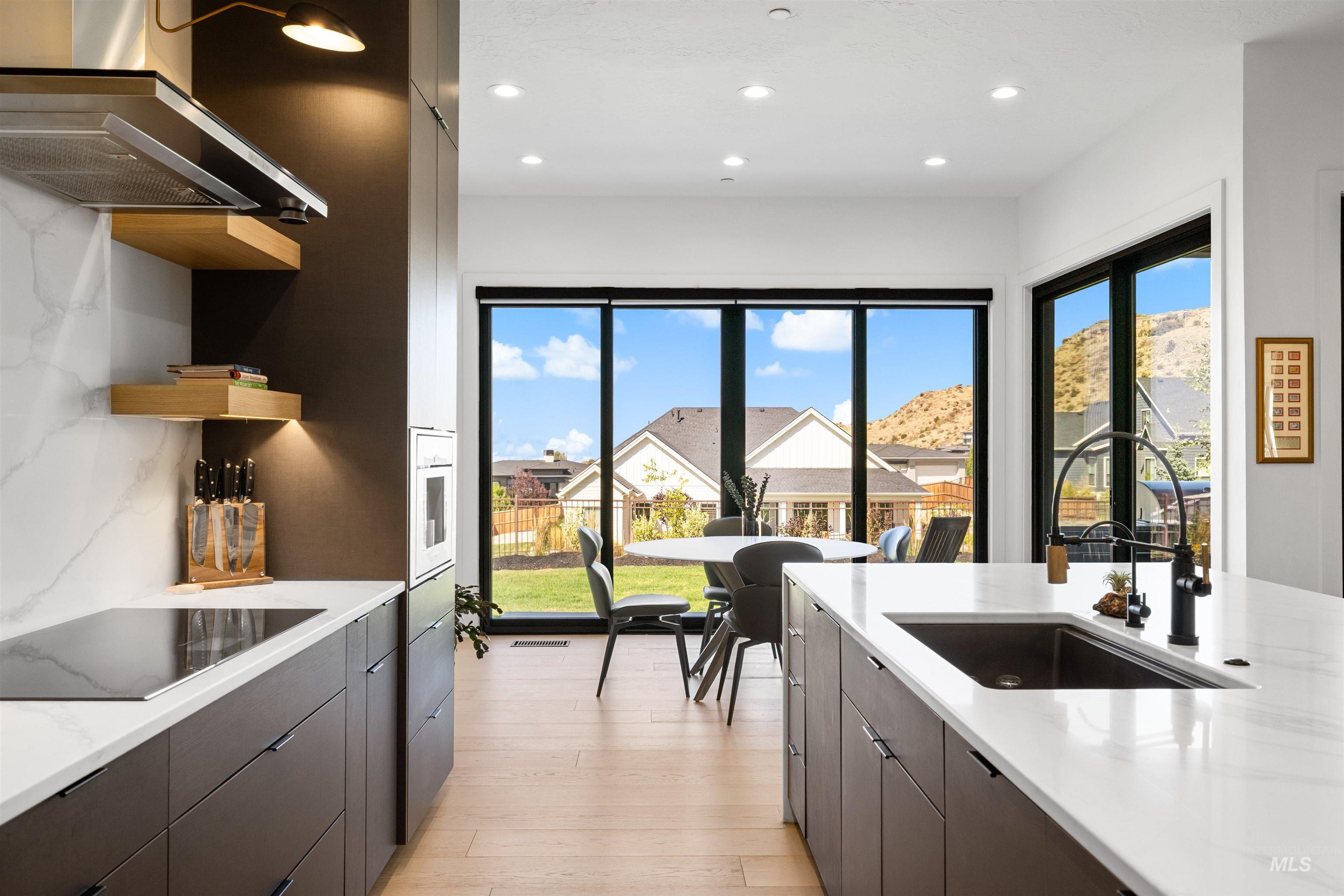 Kitchen with wall chimney exhaust hood, open shelves, healthy amount of natural light, modern cabinets, and recessed lighting