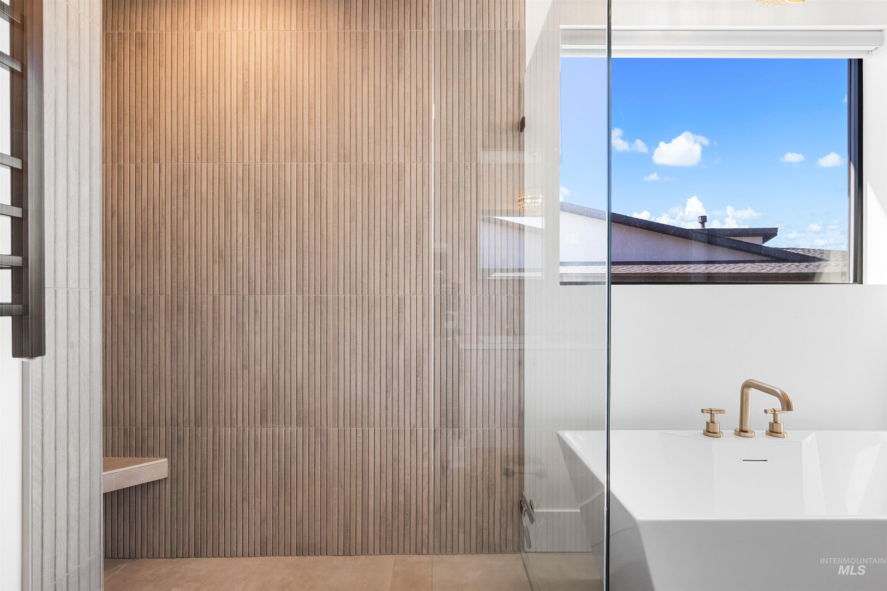 Full bathroom featuring a soaking tub and light tile patterned floors