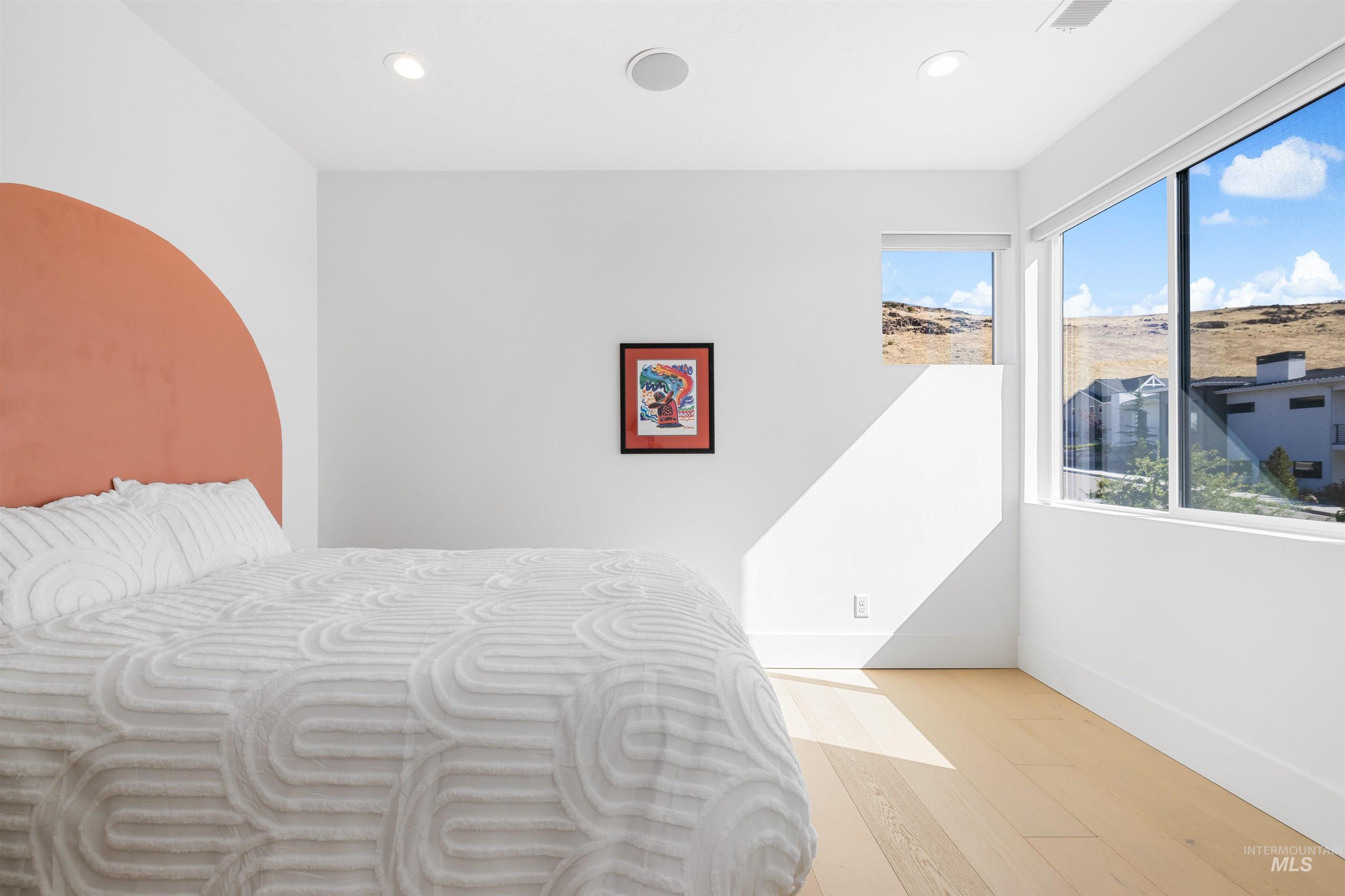 Bedroom with wood finished floors and recessed lighting