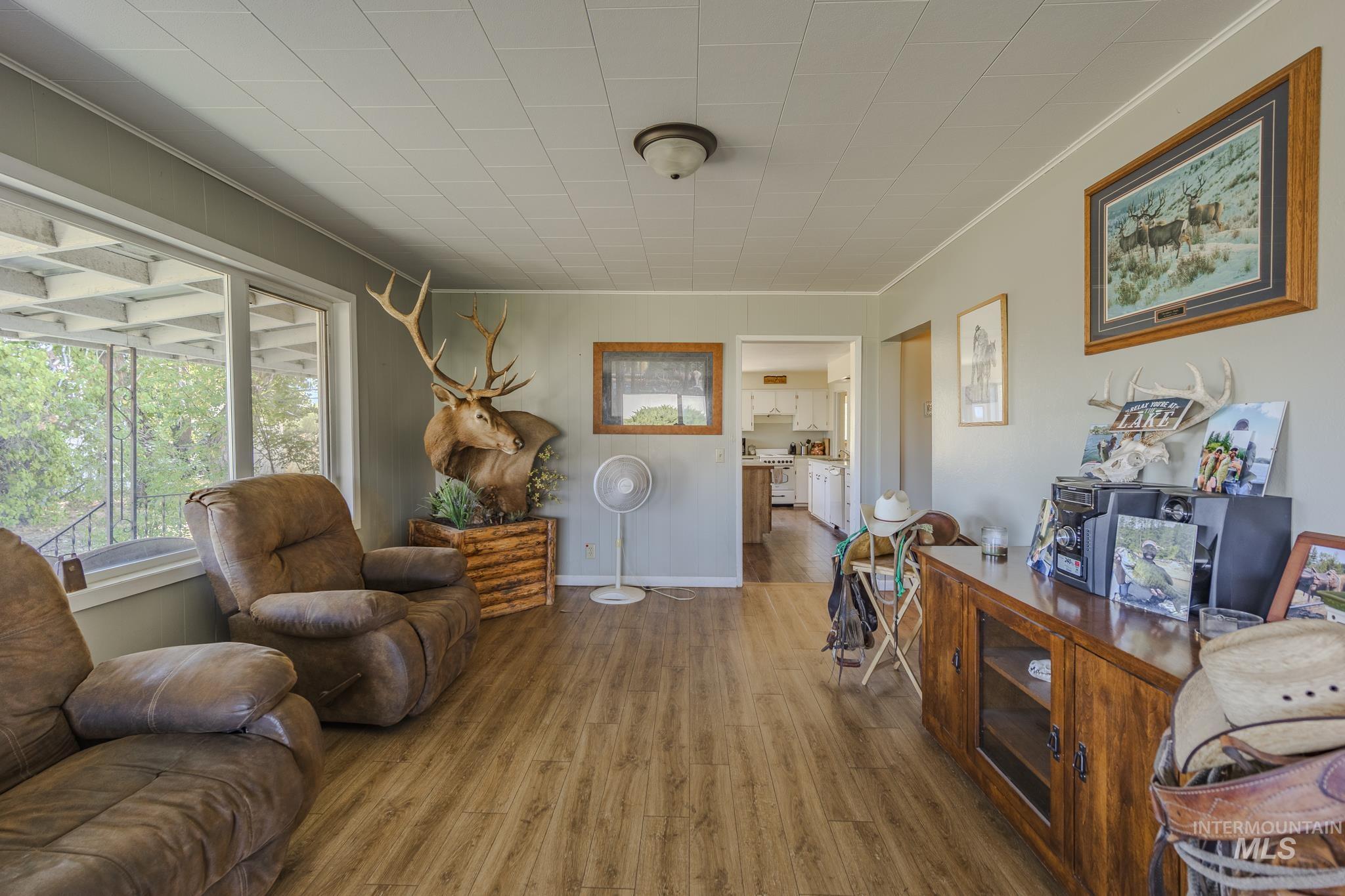 Sitting room with wood finished floors and crown molding