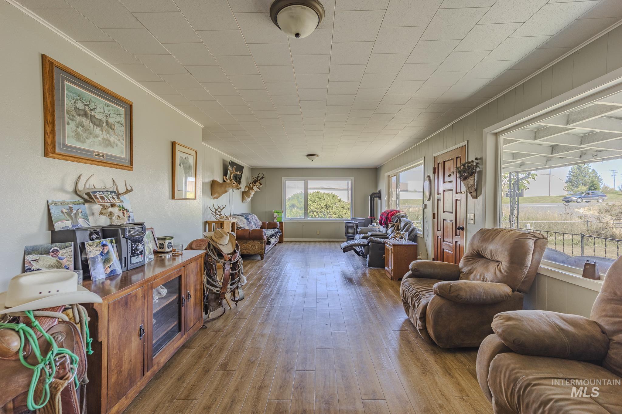 Living area with hardwood / wood-style floors and crown molding