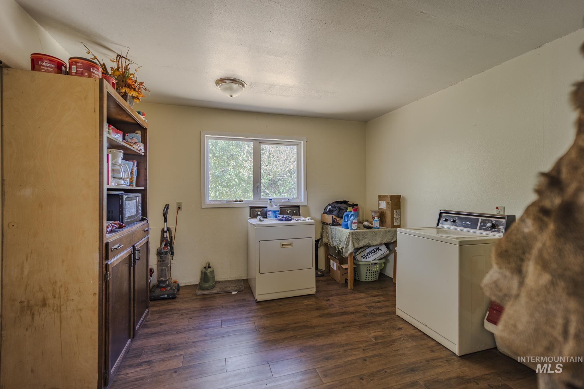 Laundry area with washer and clothes dryer and dark wood finished floors