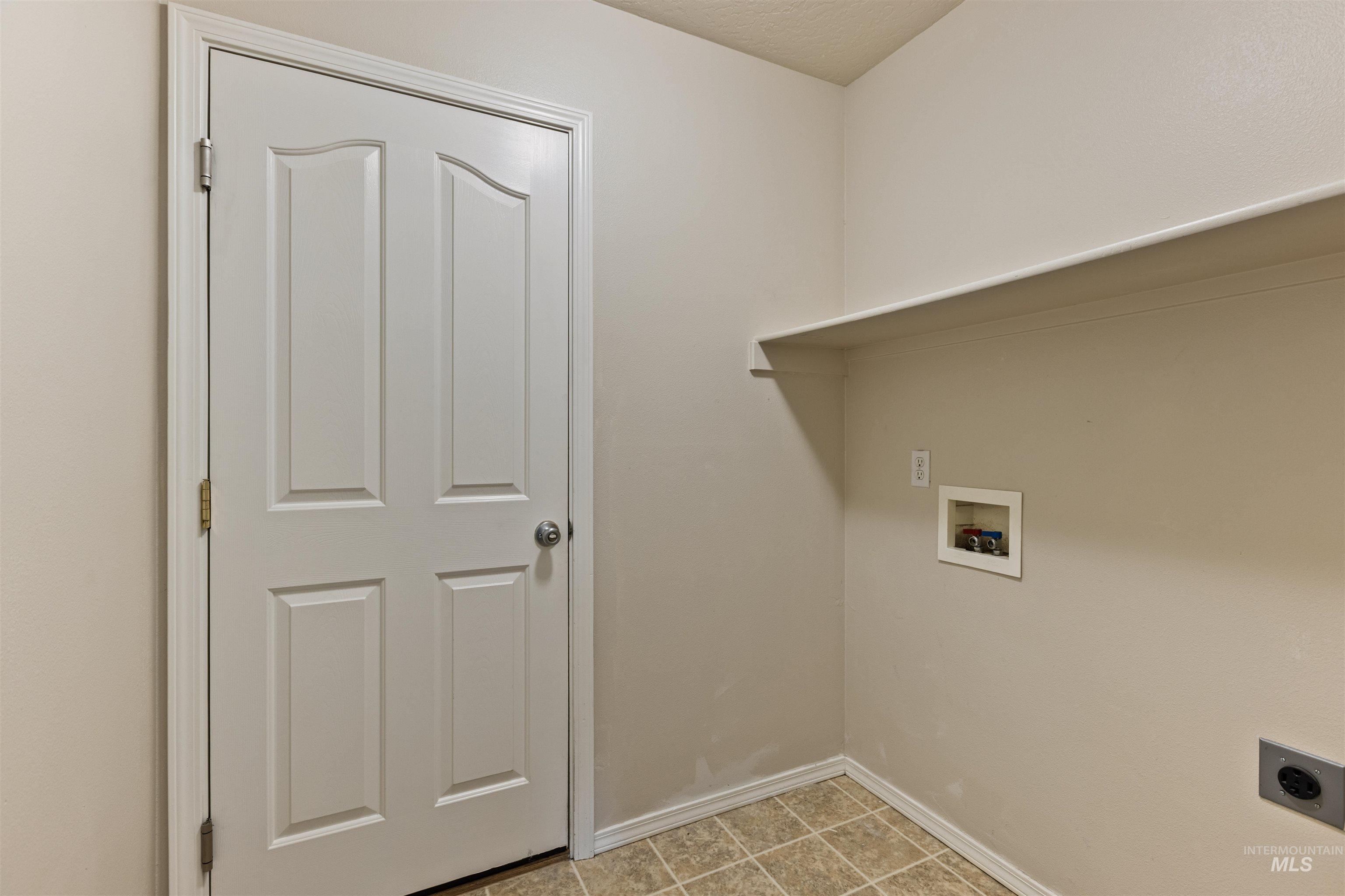 Washroom featuring washer hookup, hookup for an electric dryer, and light tile patterned flooring