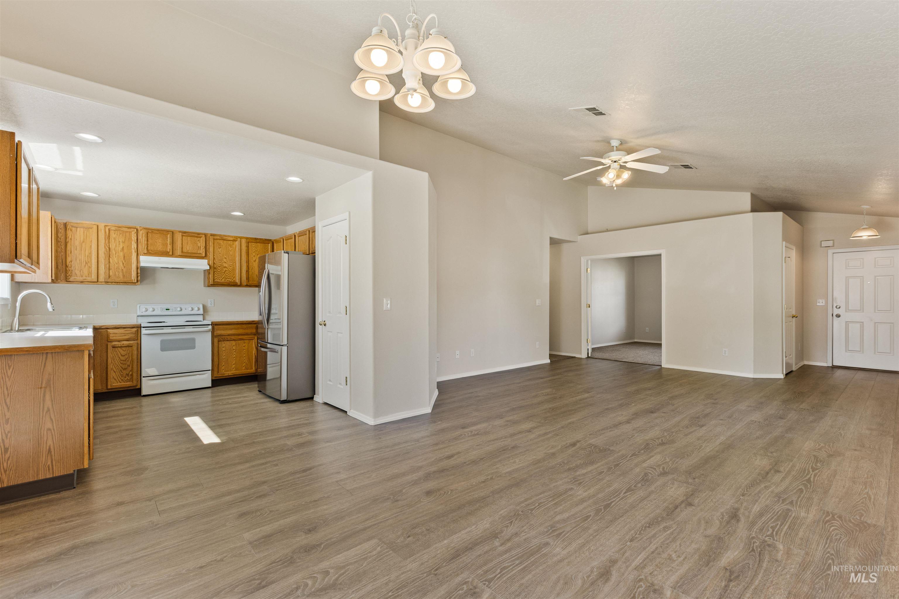 Kitchen with light countertops, pendant lighting, light wood finished floors, lofted ceiling, and recessed lighting