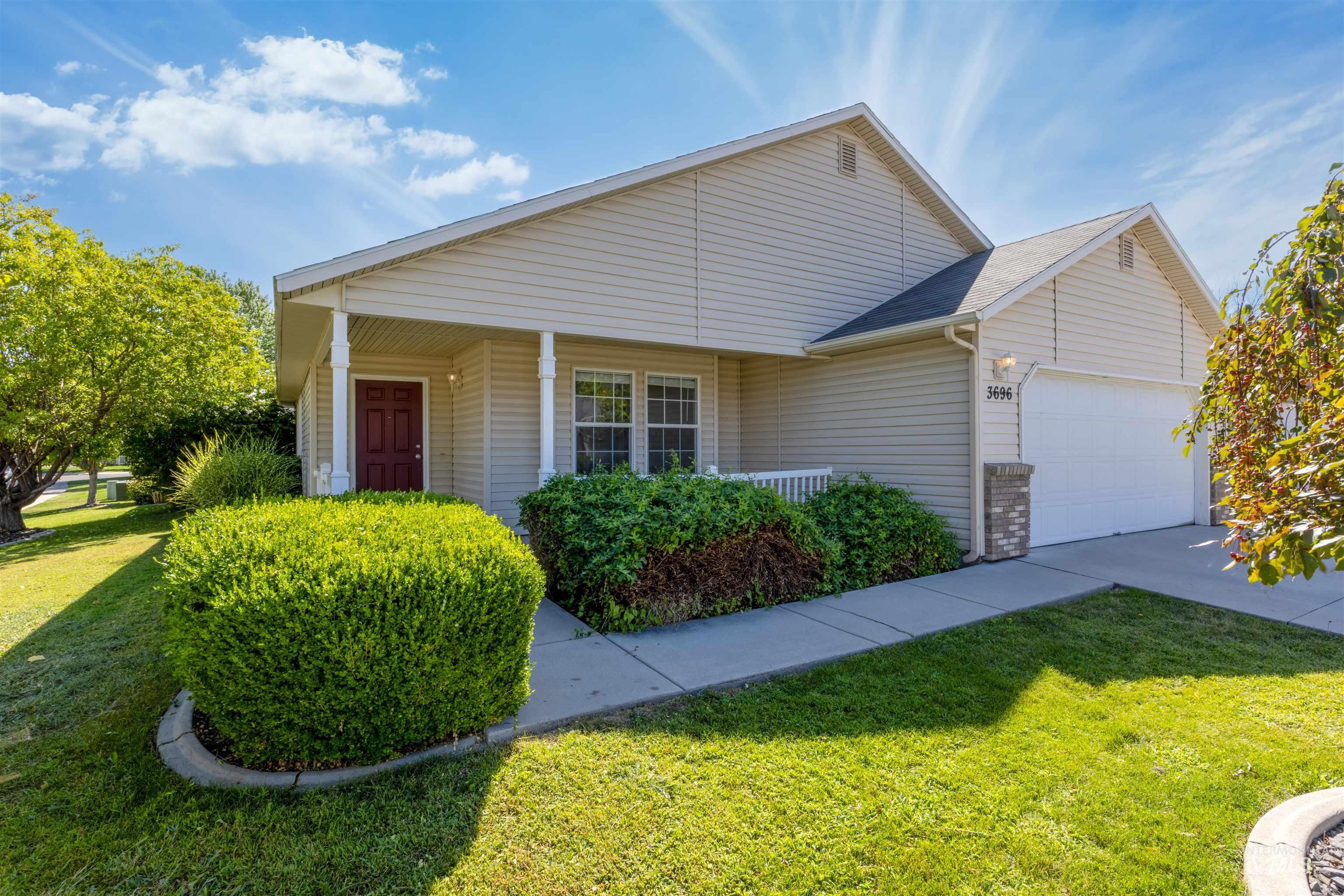View of front of house with a garage, a front yard, a porch, and concrete driveway
