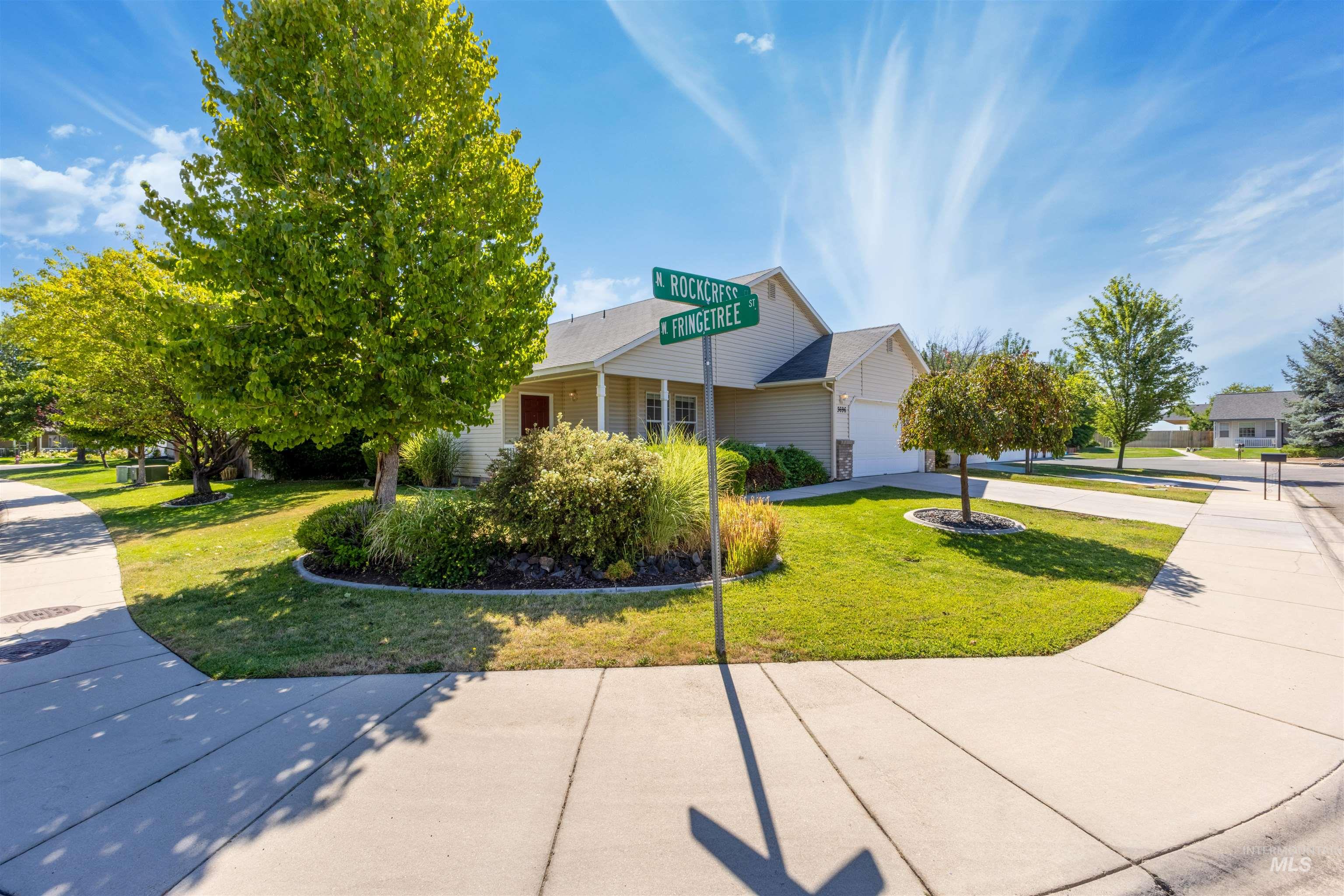 View of front of property with a garage, concrete driveway, and a front yard