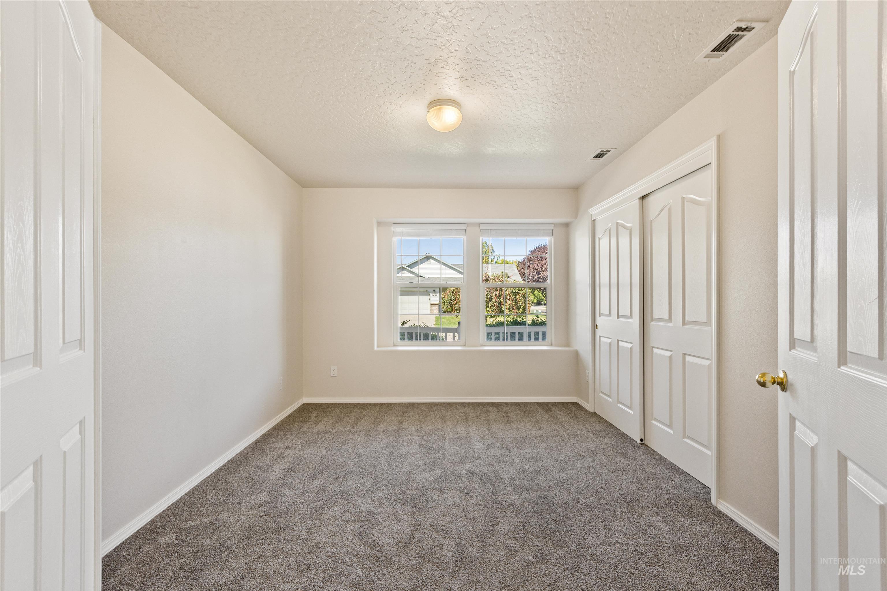 Unfurnished bedroom featuring carpet floors, a closet, and a textured ceiling
