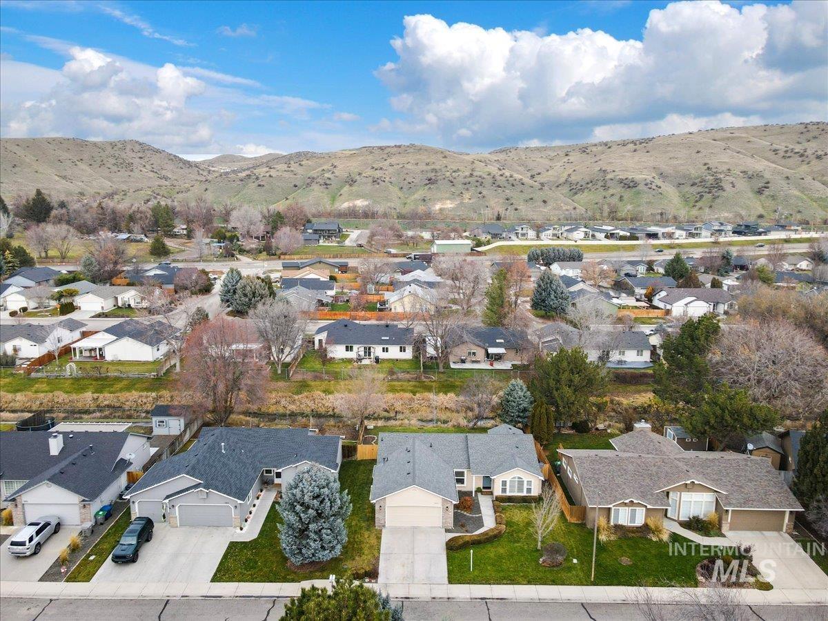 Aerial view of property's location with nearby suburban area and a mountain backdrop