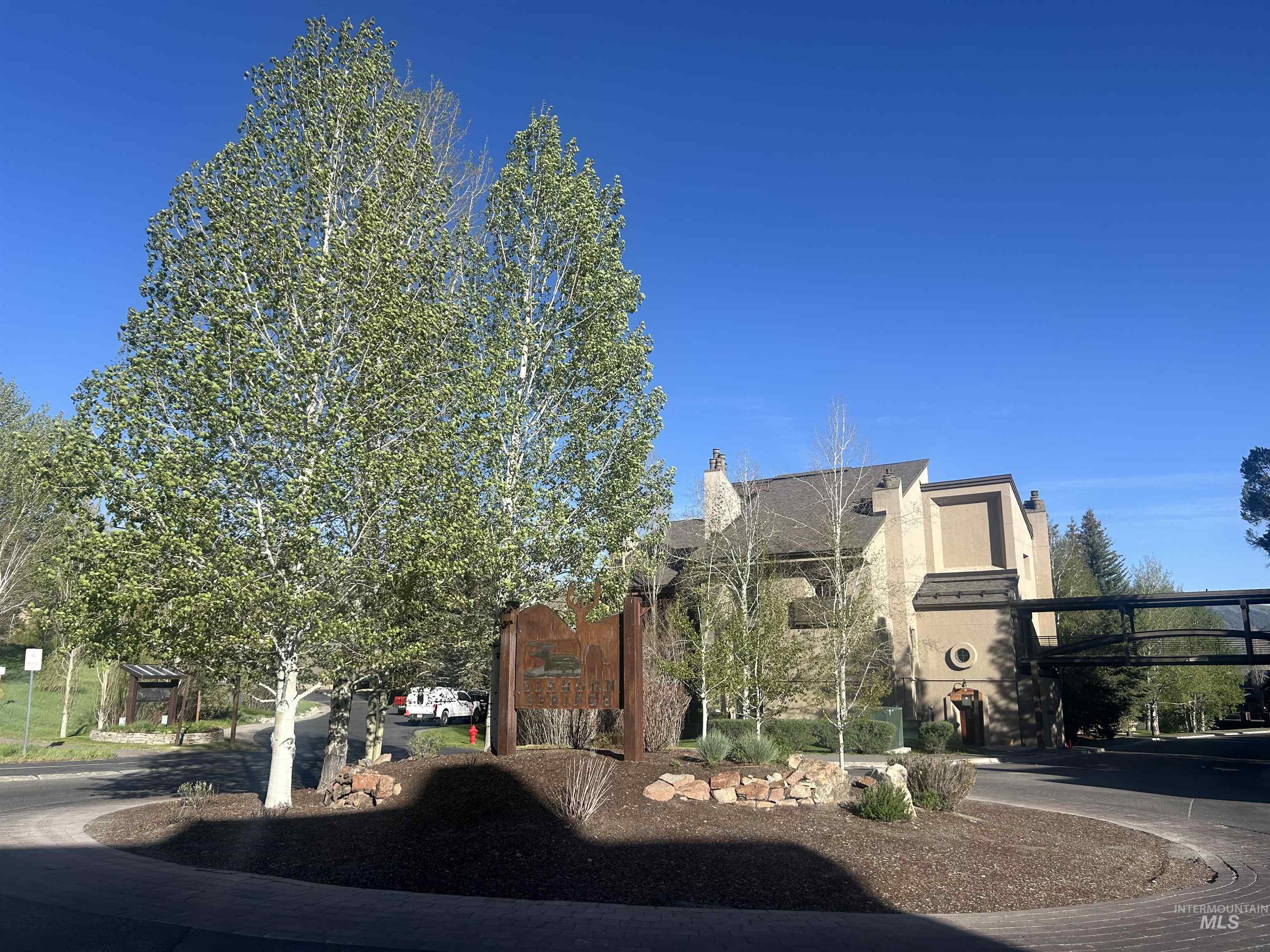 Multi-story building featuring stucco exterior, pitched roofline, and prominent chimneys