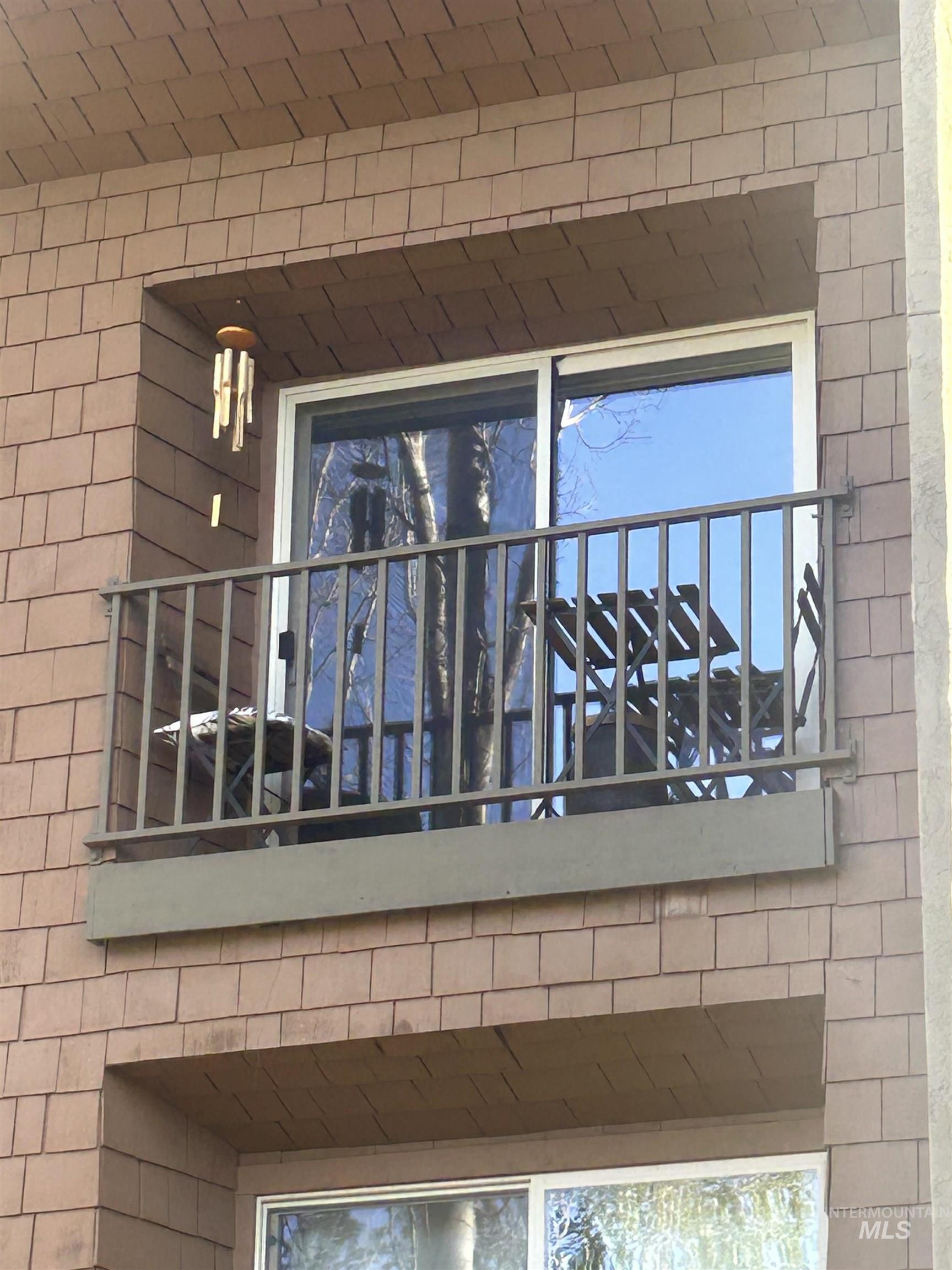 Private balcony featuring a metal railing and sliding glass door