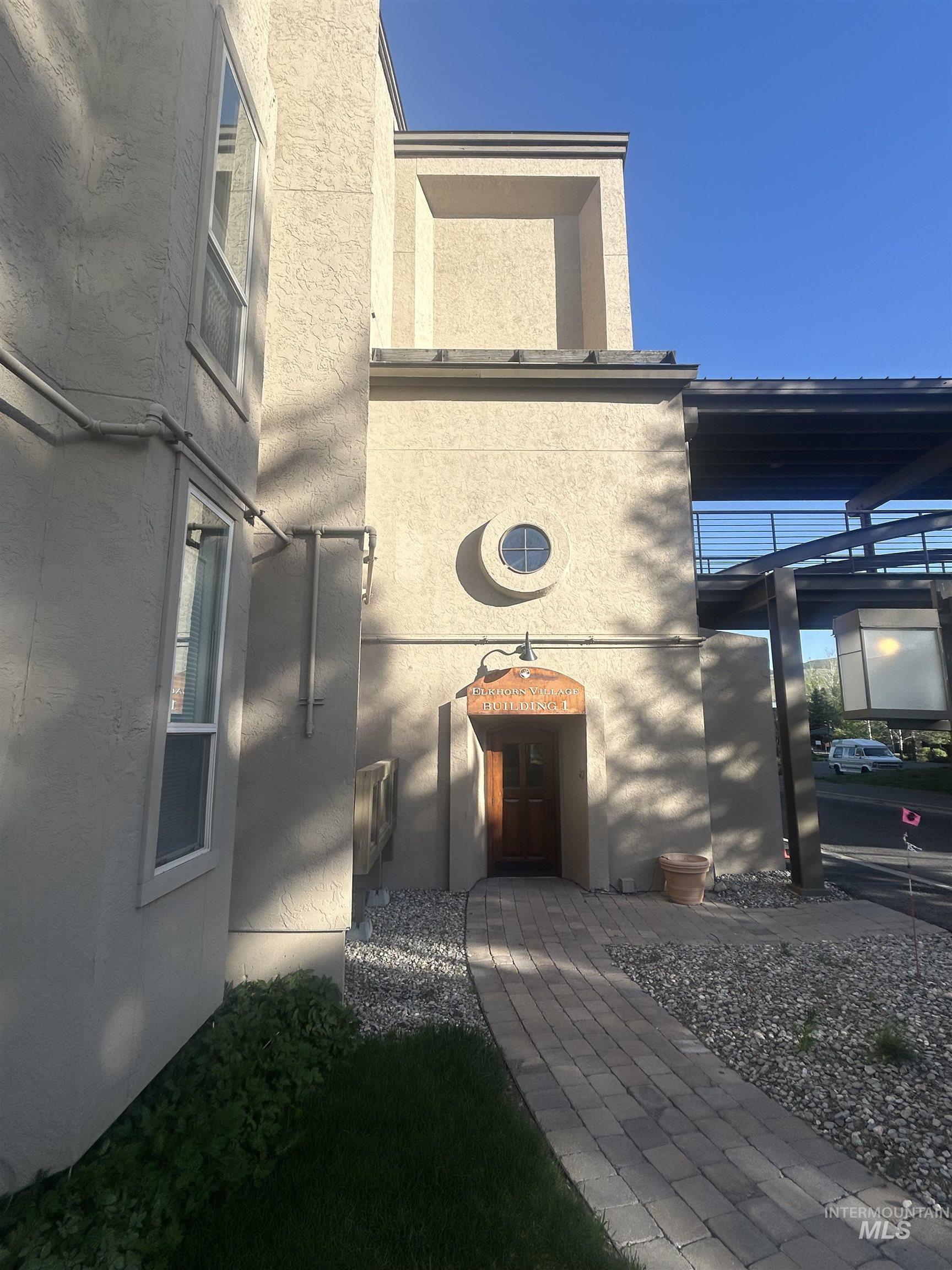 Stucco exterior with a paver walkway leading to a recessed entry